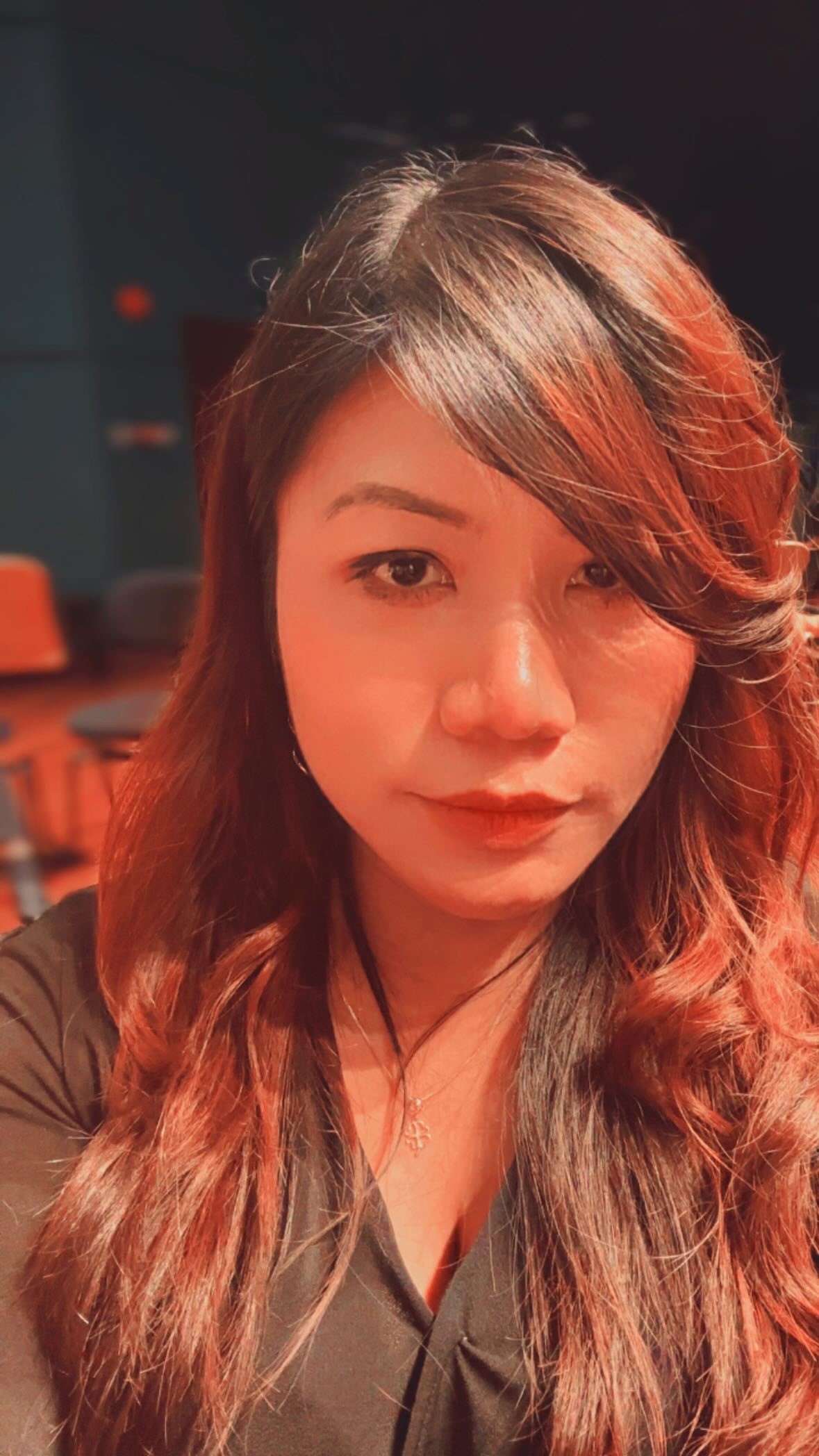 Portrait of a woman with long brown hair and green eyes