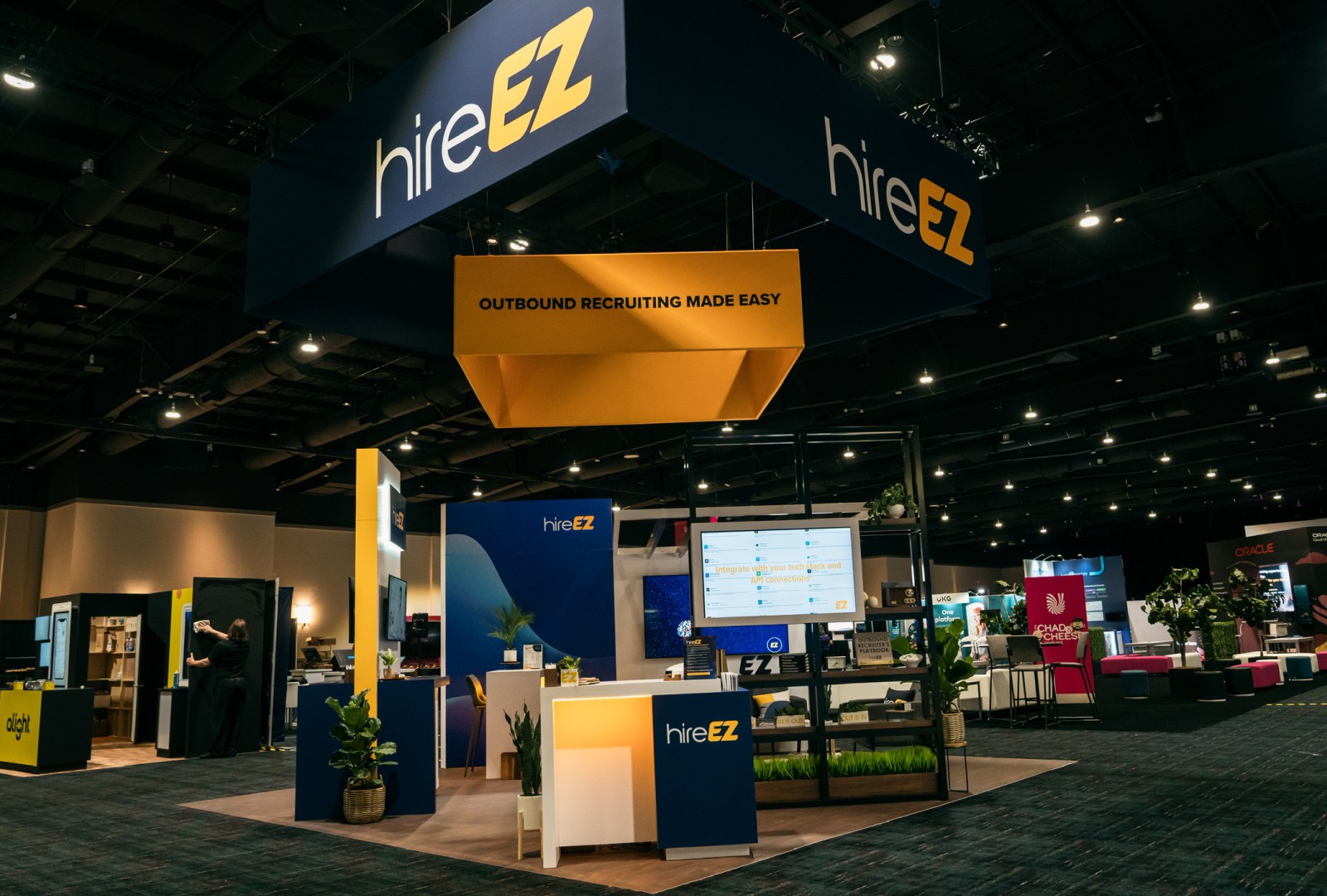 HireEZ both in HR Technology Confrences venue showing the booth in a dark lighting before venue members walk through the confrence