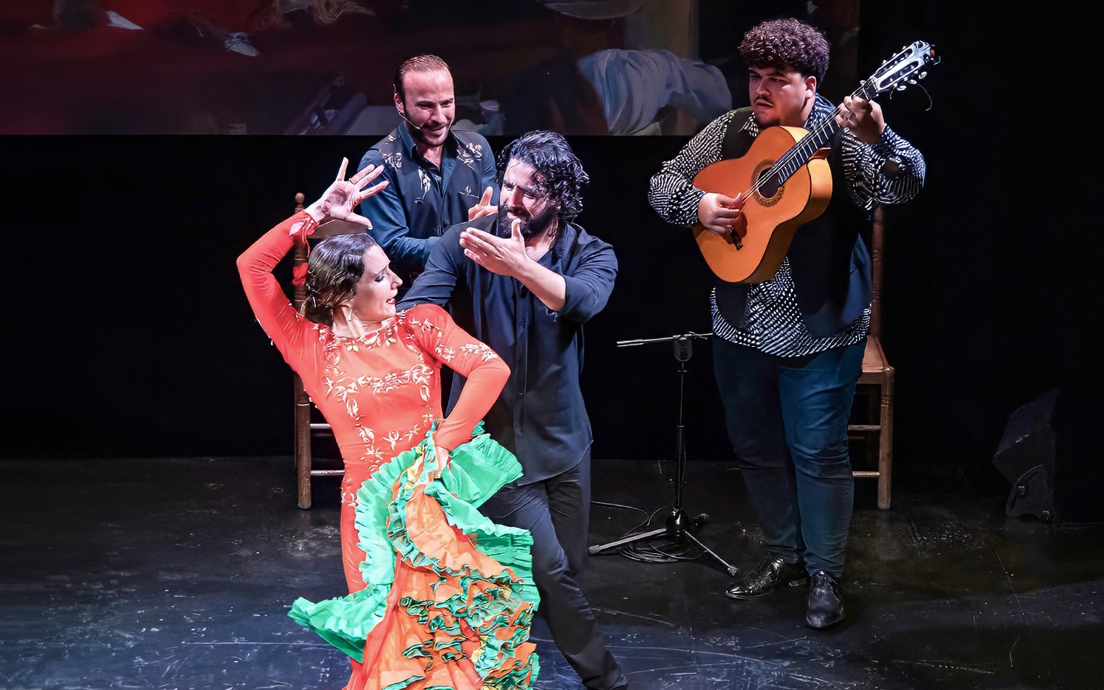 Flamenco dancers and guitarist performing at Teatro Flamenco Triana.