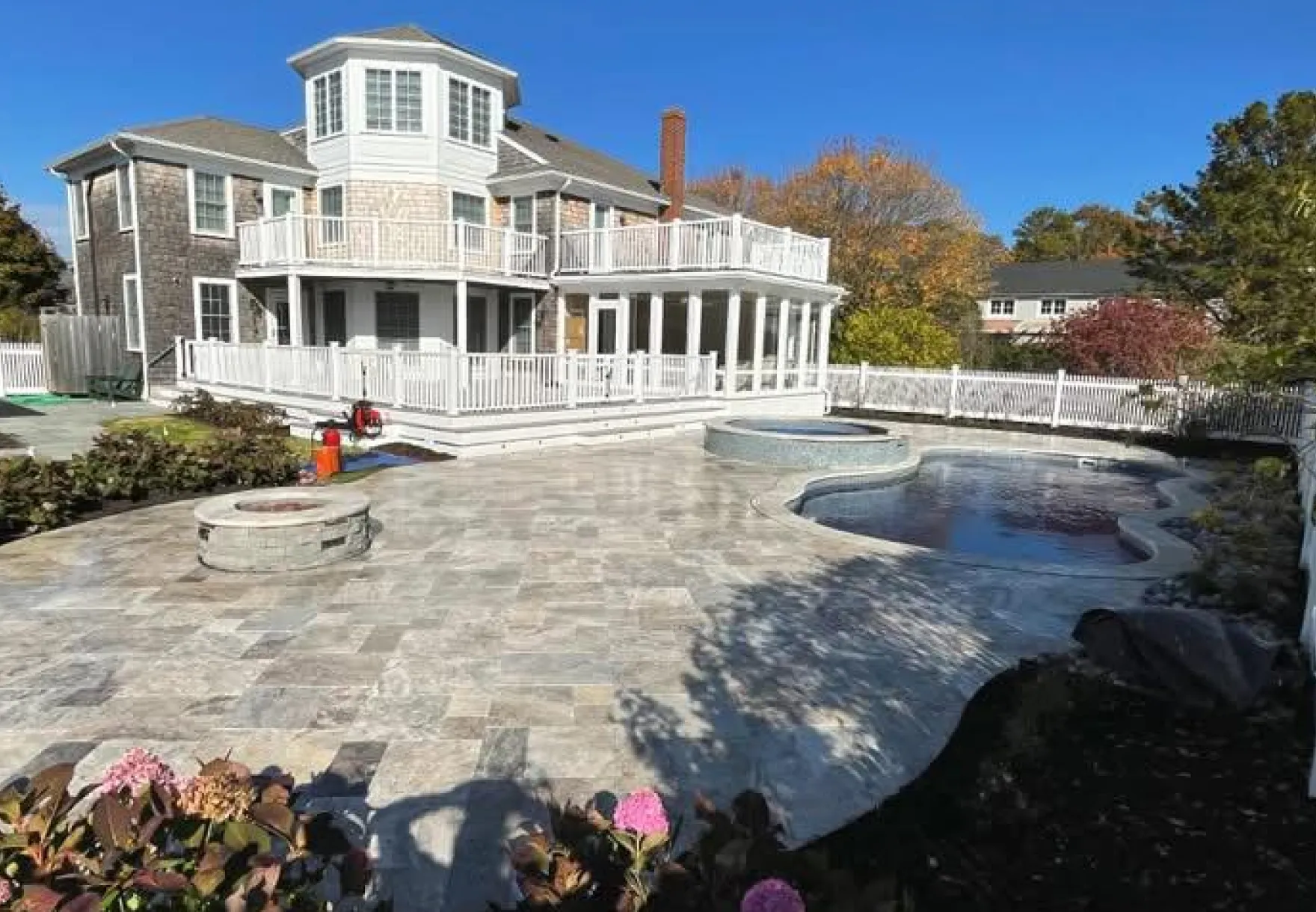 Price Landscape and Construction finished project at a residental home of a large stone patio, firepit, and pool