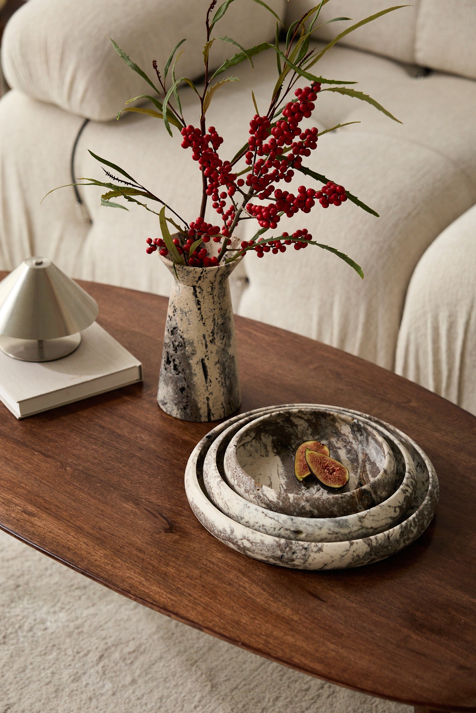 Marmorvase und dekorative Steinschalen auf Holztisch