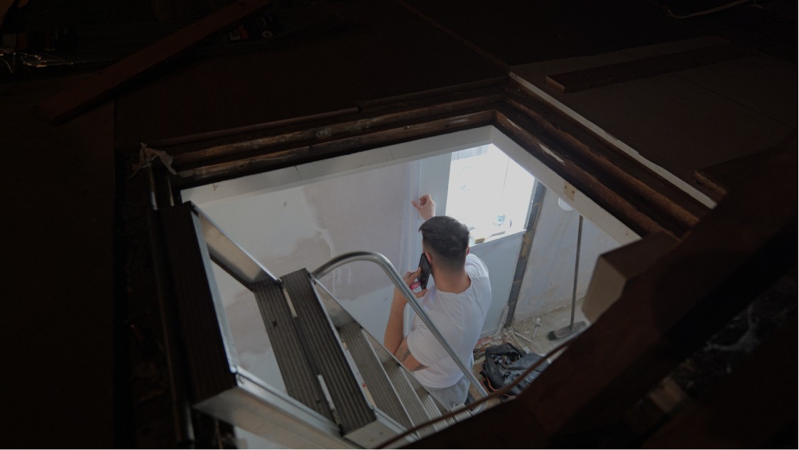 Contractor working from ladder during plastering and refurbishment works inside Kent home