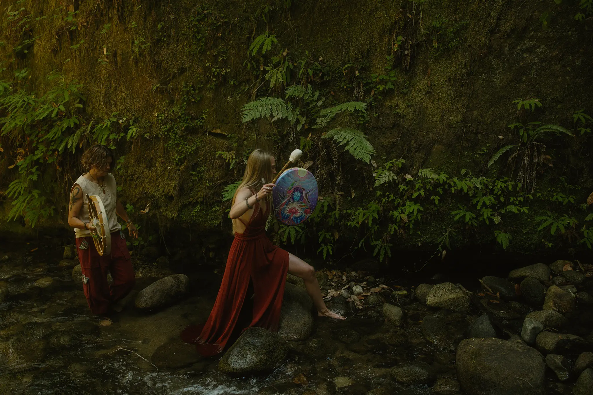 Two plant medicine guides performing ceremony by a jungle stream