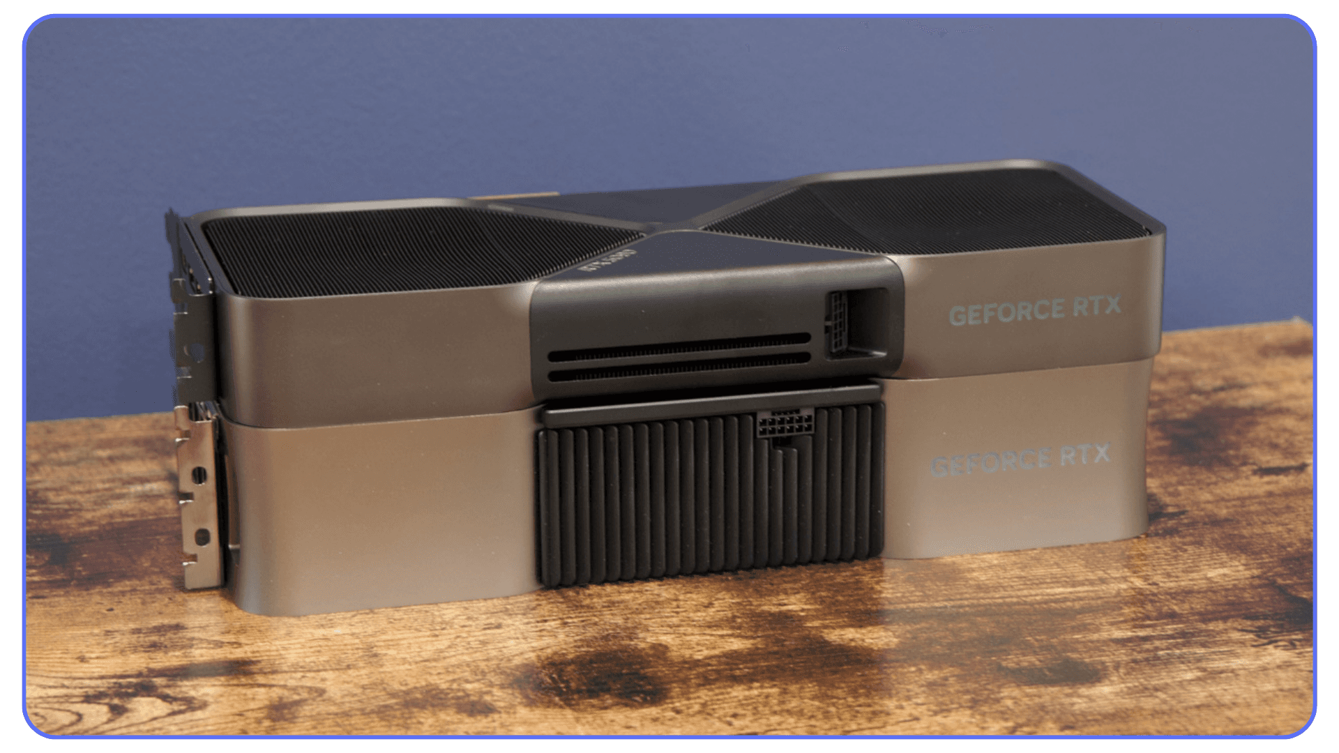 Stacked NVIDIA GeForce RTX GPUs placed on a wooden desk, illustrating large heatsink design and cooling capacity.