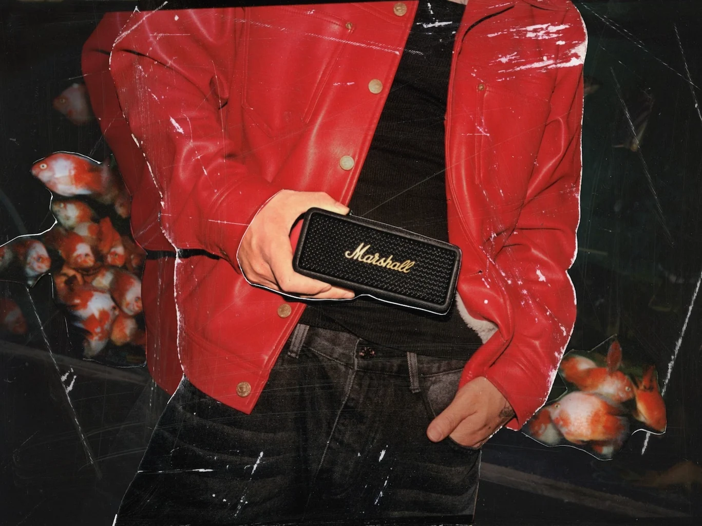 Man wearing red jacket holding bluetooth speaker