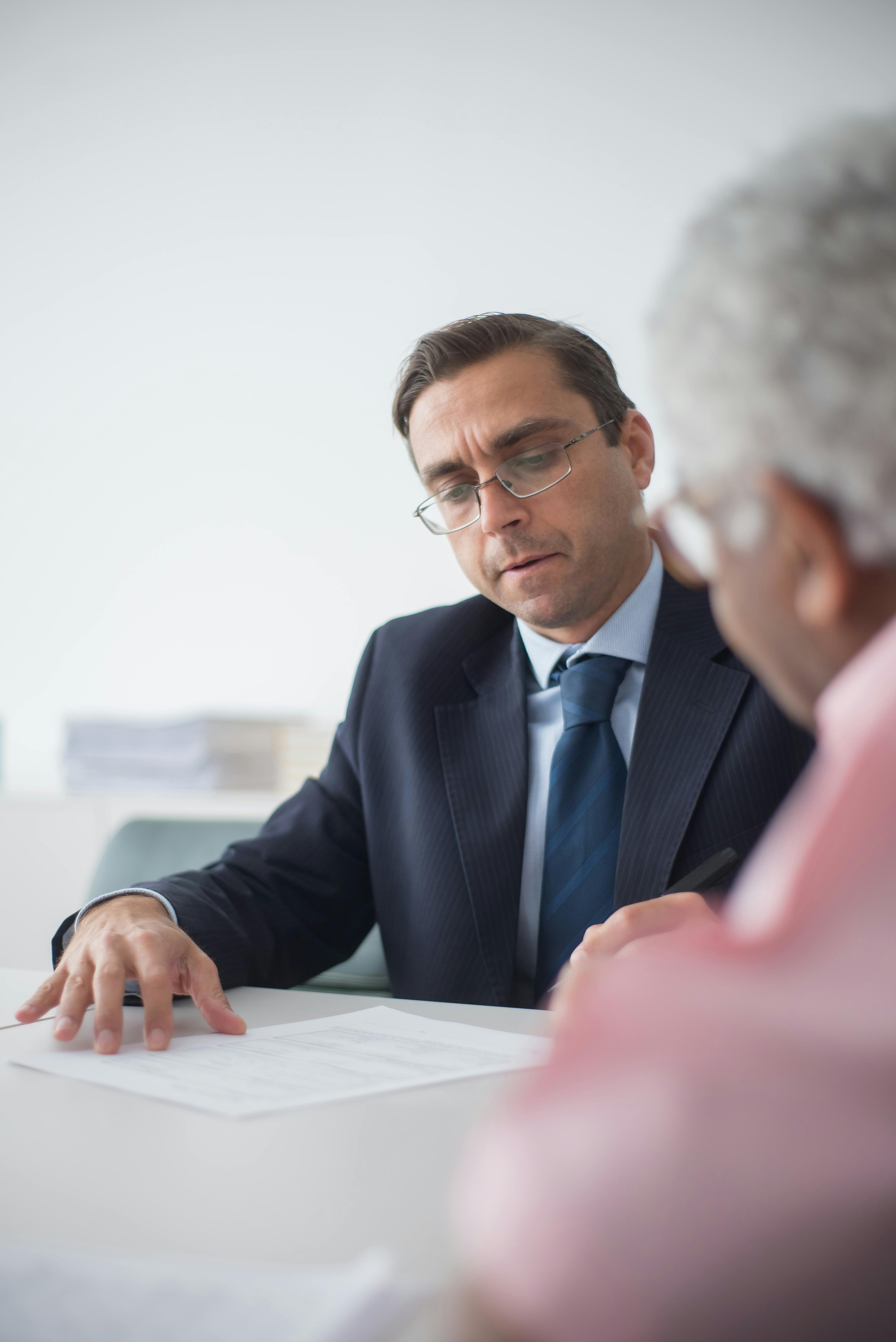 Insurance agent reviewing policy renewal documents with clients during a consultation meeting
