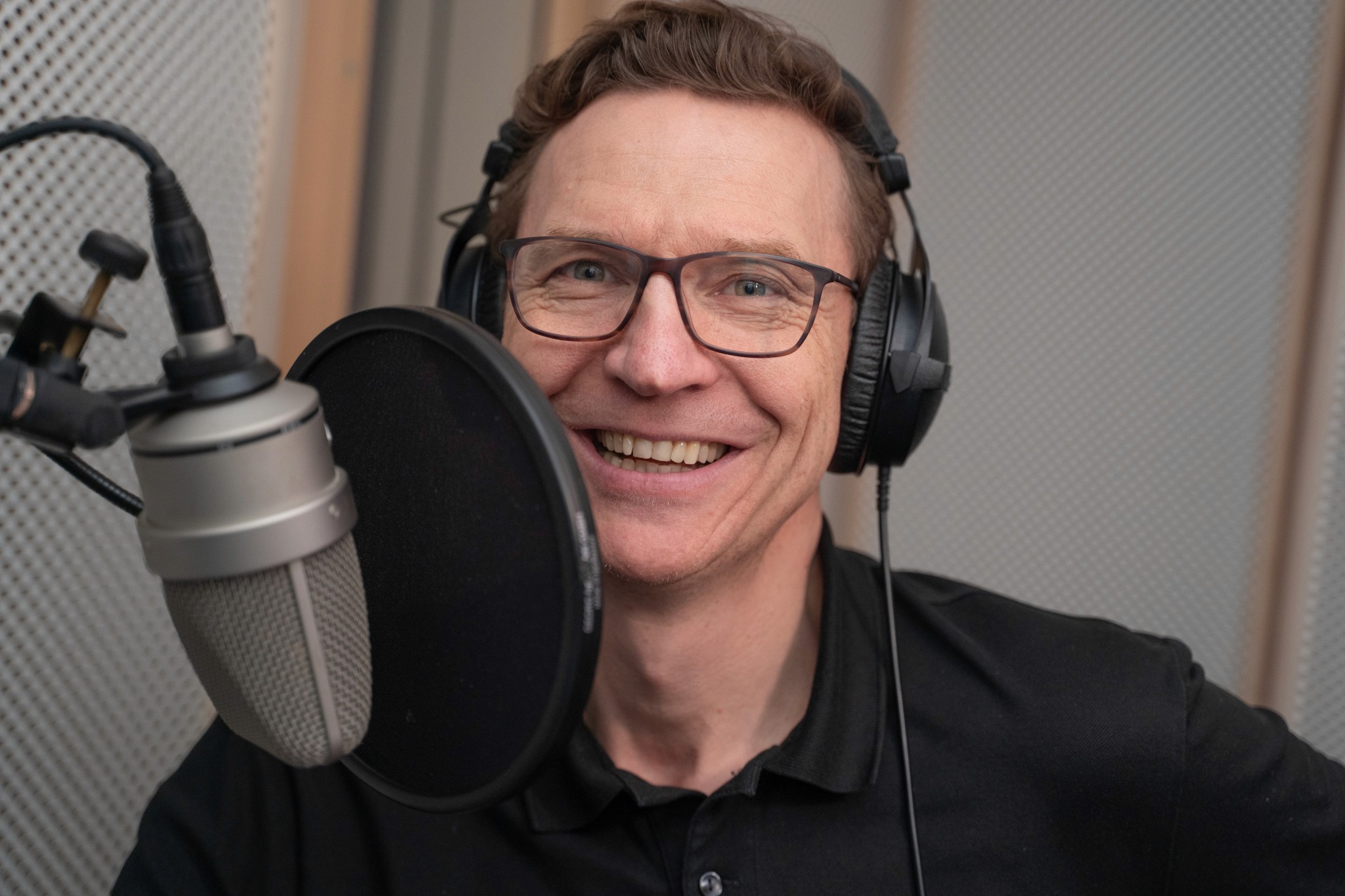 Man with headphones talking into a microphone