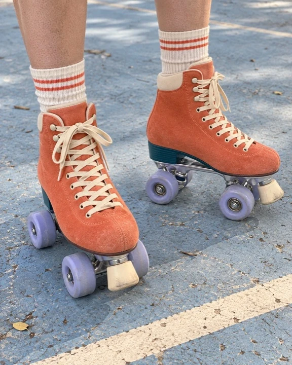 Illustrative buyer phone photo of coral skates and striped socks on an outdoor court