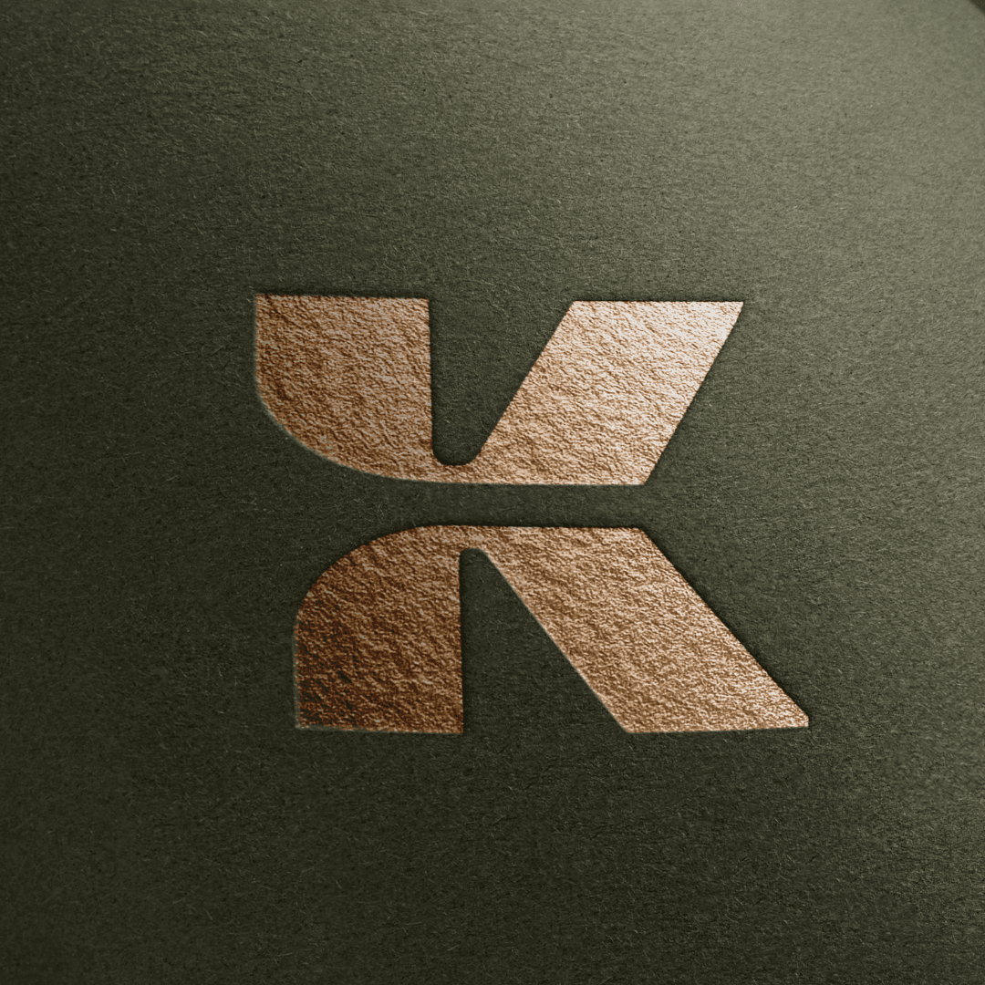 Three individuals gathered around a table, engaged in discussion while examining a laptop.