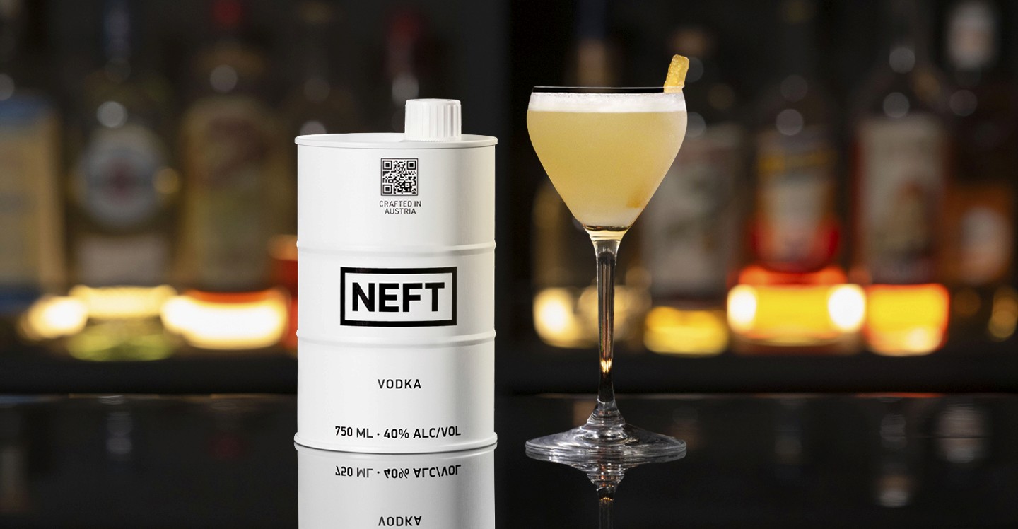 A NEFT Barrel and a glass of Kat's Pajamas on a bar counter.