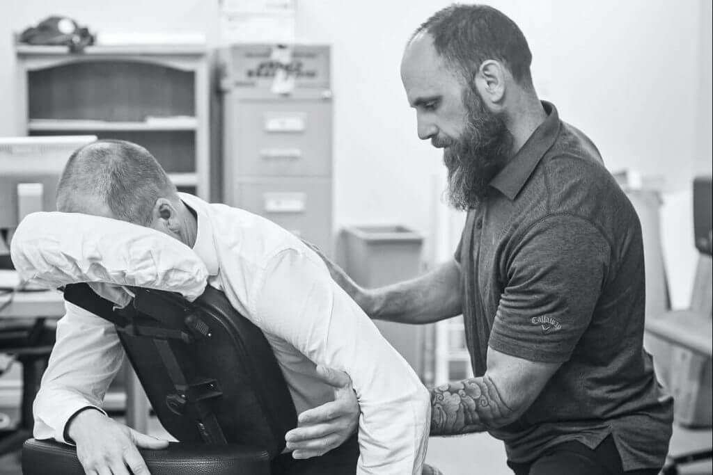 Employee receiving seated neck & shoulder massage at work