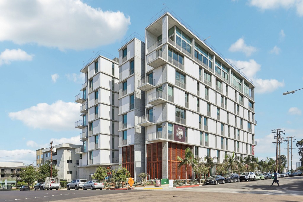 Modern apartment building of Kaya in Bankers Hill with white, modular facade and large windows, set against a blue sky.