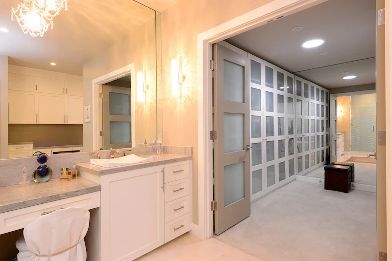 Elegant master bath with dual vanity and frosted glass closet doors in Harbor Ridge Transitional Remodel.