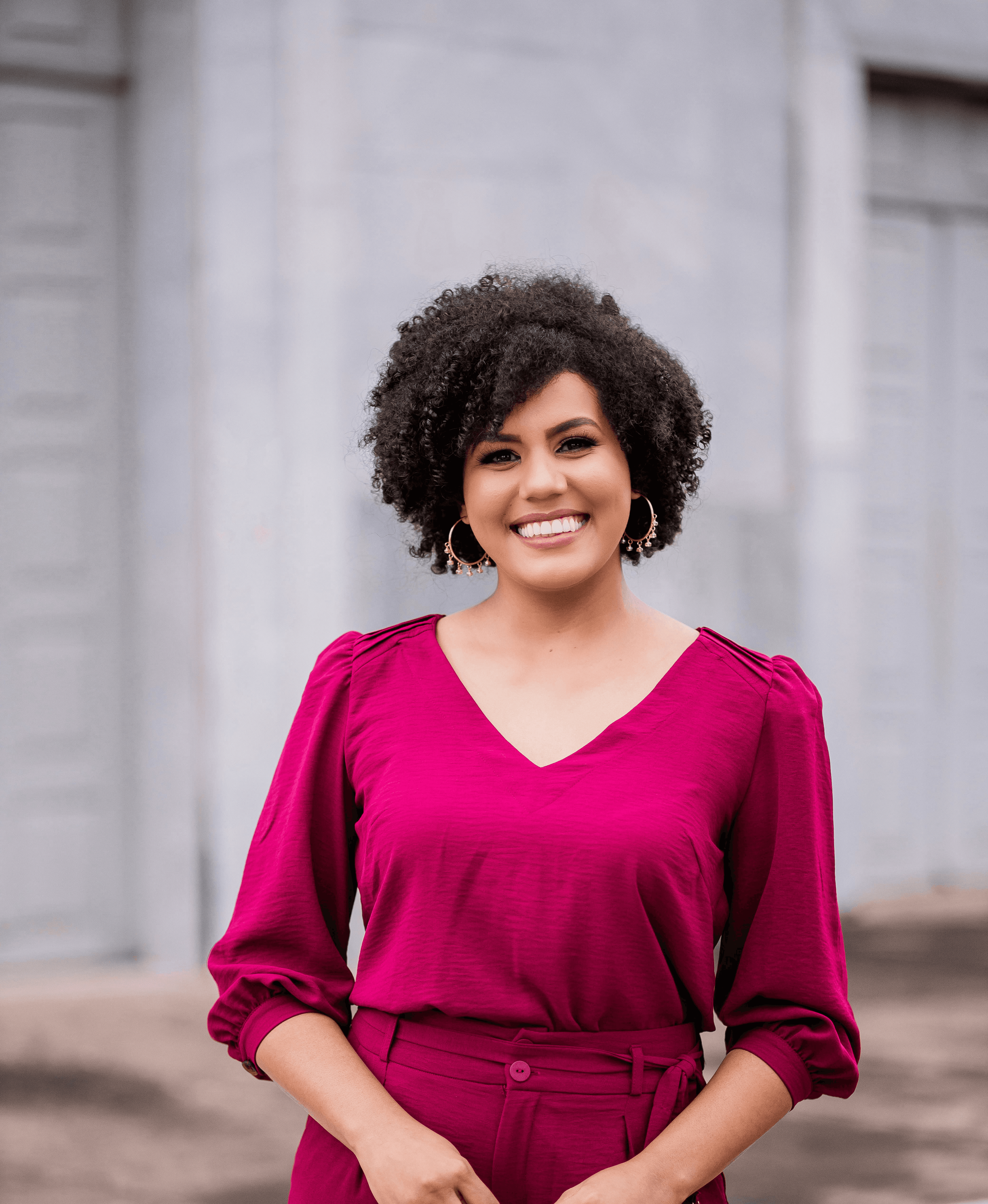 woman in red long sleeve shirt standing near white wall during daytime