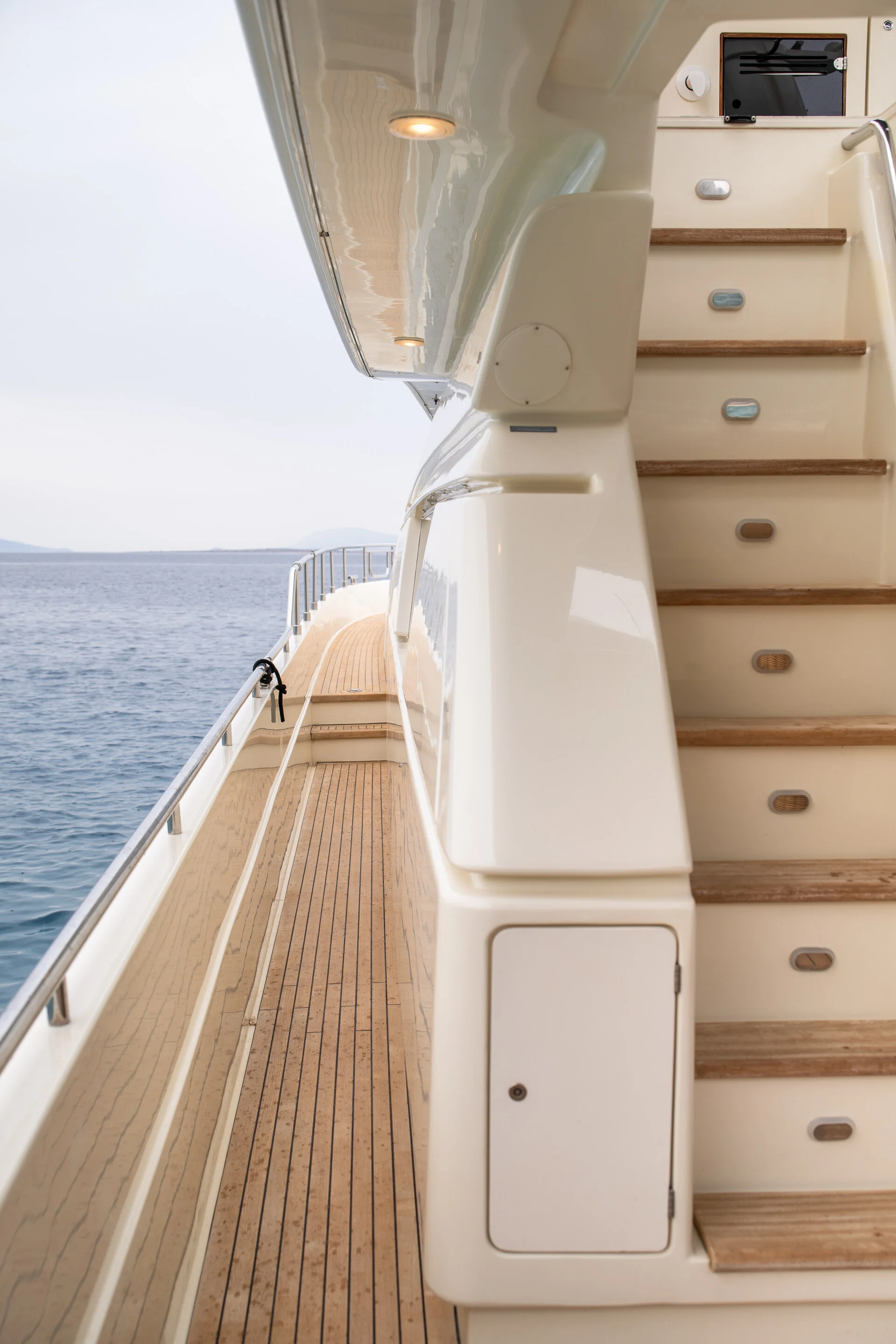 White Rock 36 speedboat with captain at helm cruising calm blue waters near Paros coastline with hills in background.