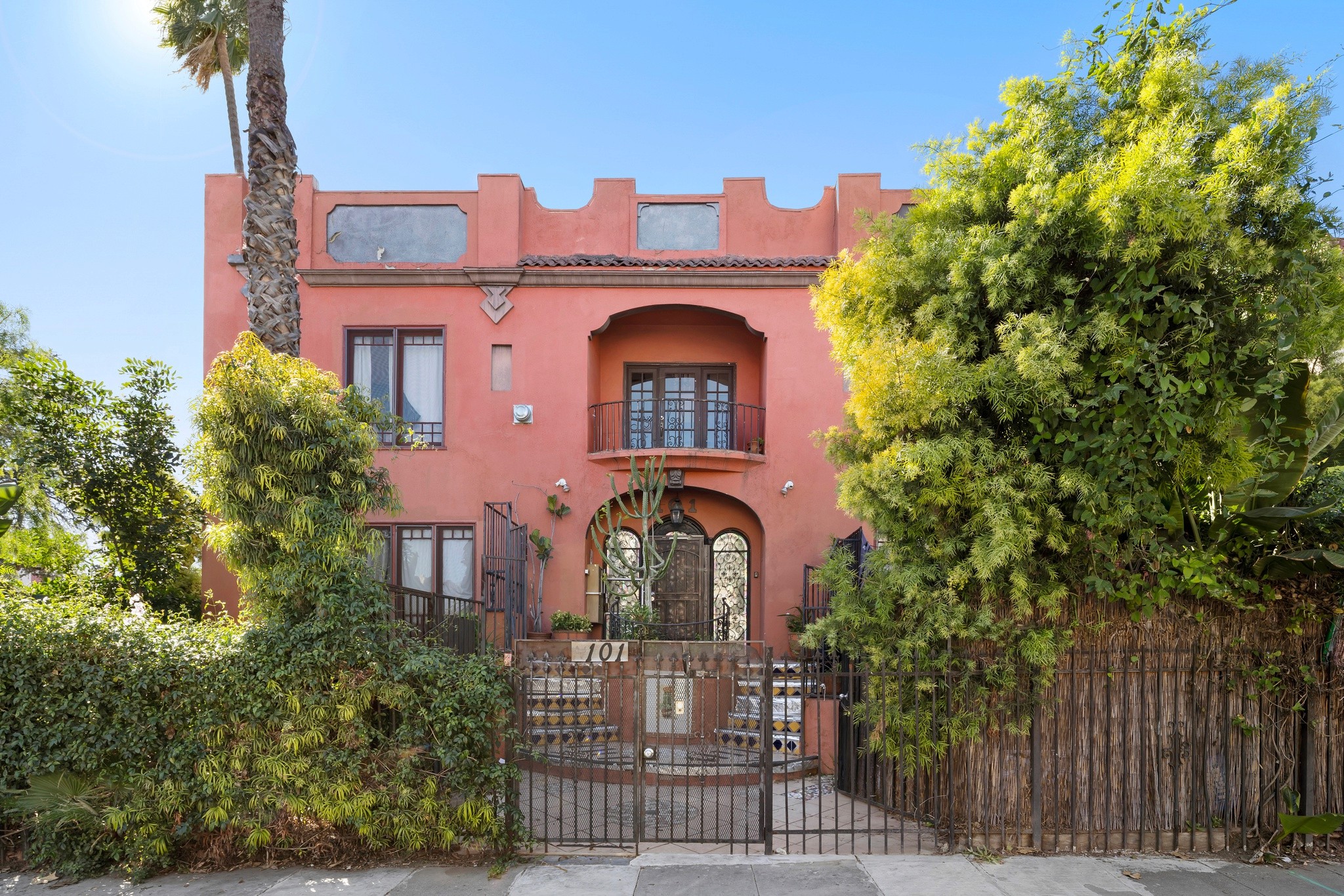 Front exterior of Spanish-style multifamily building with gated entry at 101 N Kenmore Ave.