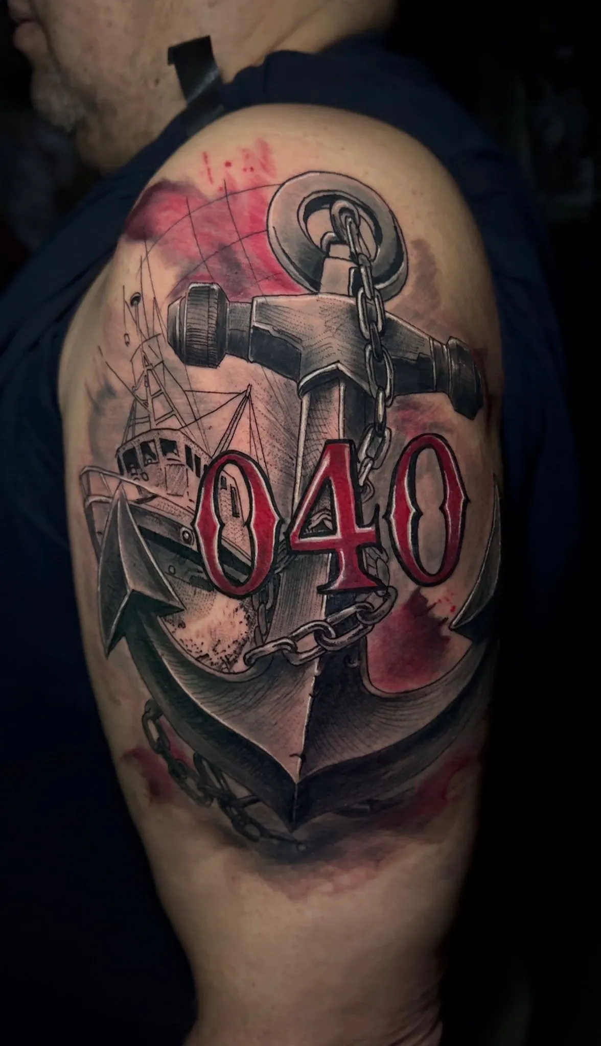 Anchor and ship tattoo with number 040 on upper arm at Calavera Ink Berlin