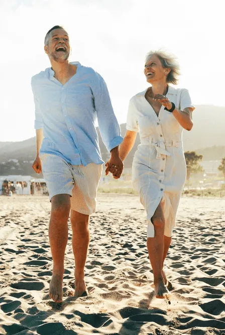 Old retired couple walking on beach