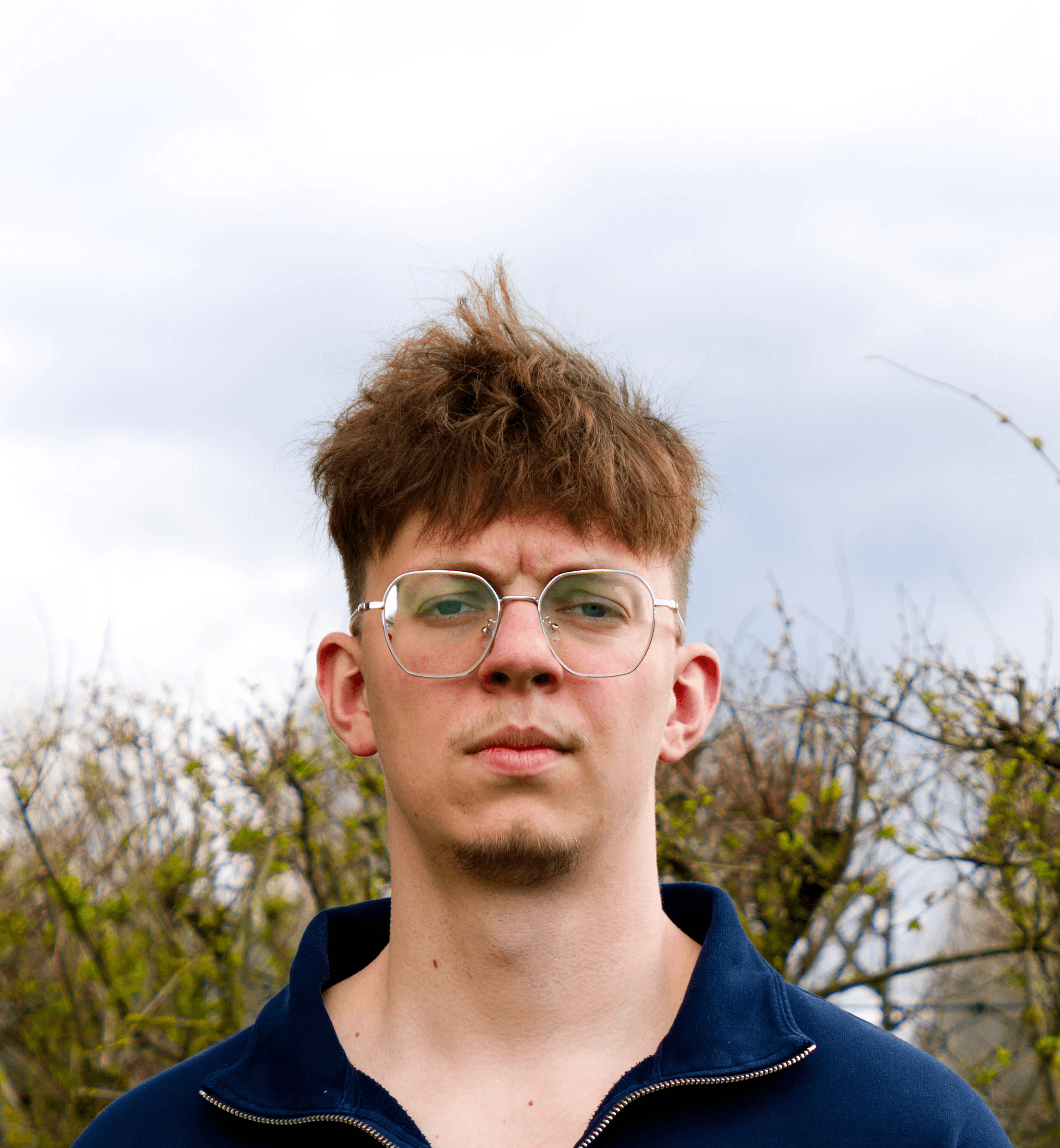 Young man in gray linen blazer over white henley shirt