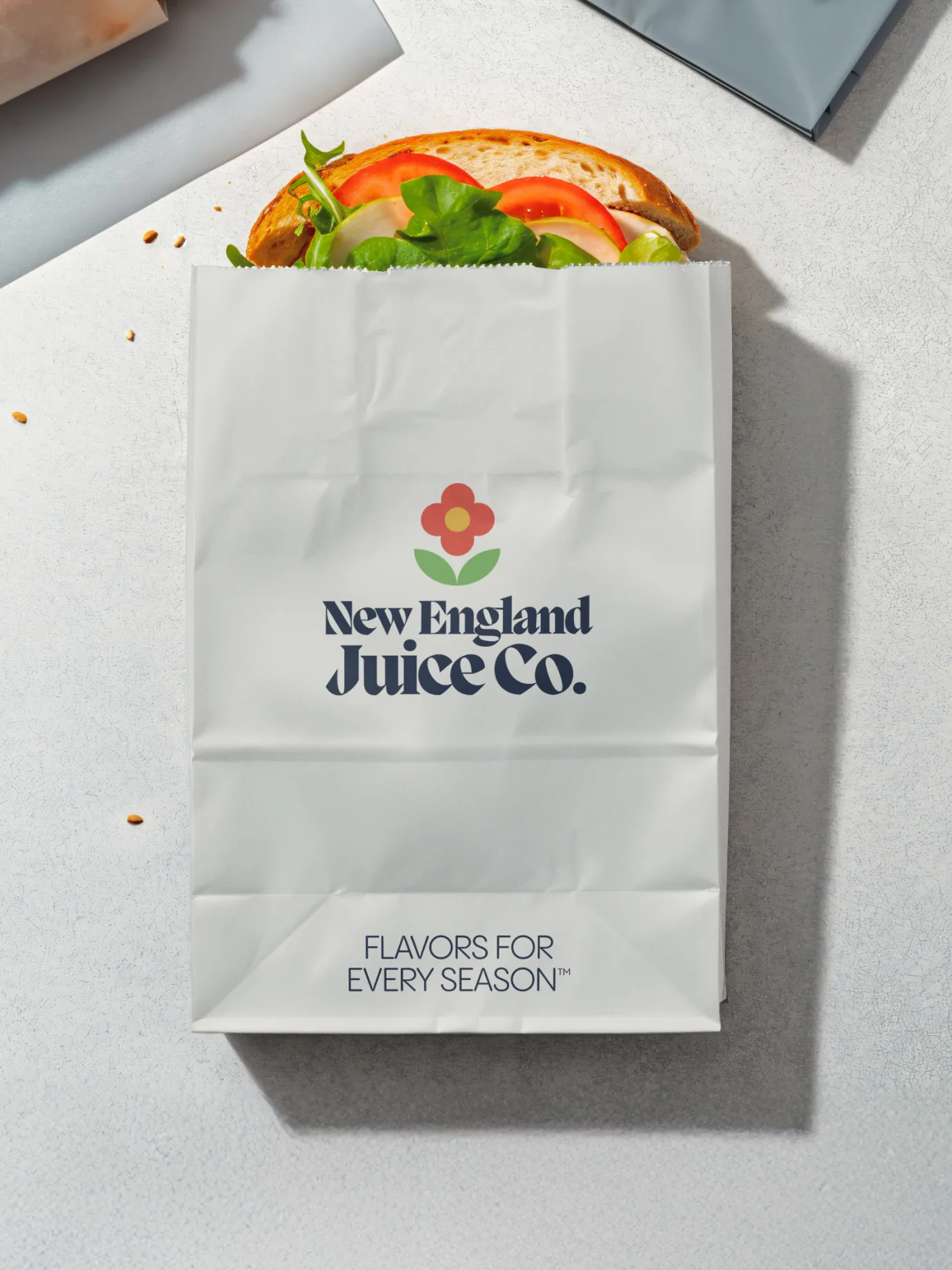 New England Juice Co. — Sandwich in branded paper wrapper — Packaging collateral