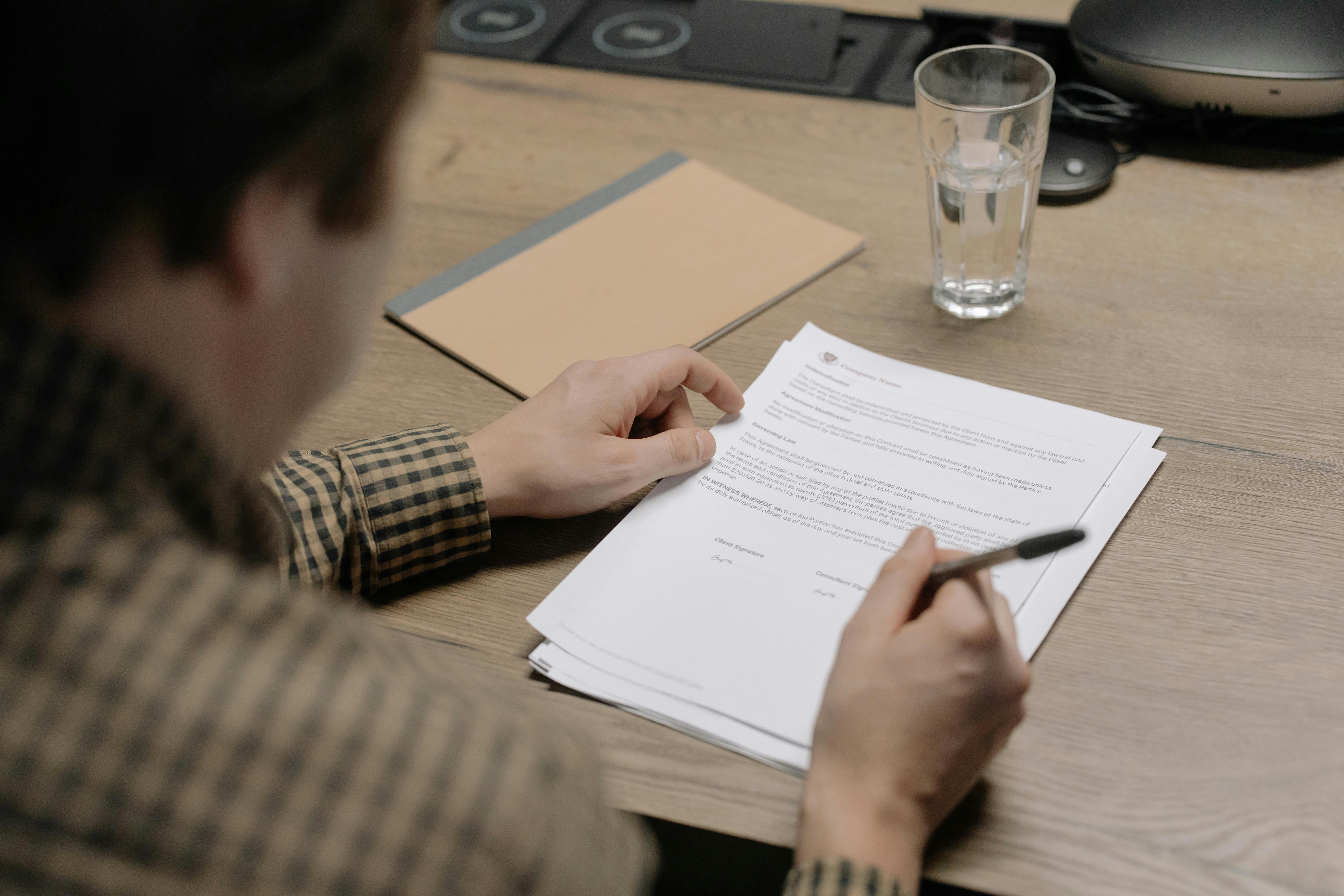 Une personne signe des docuemnts