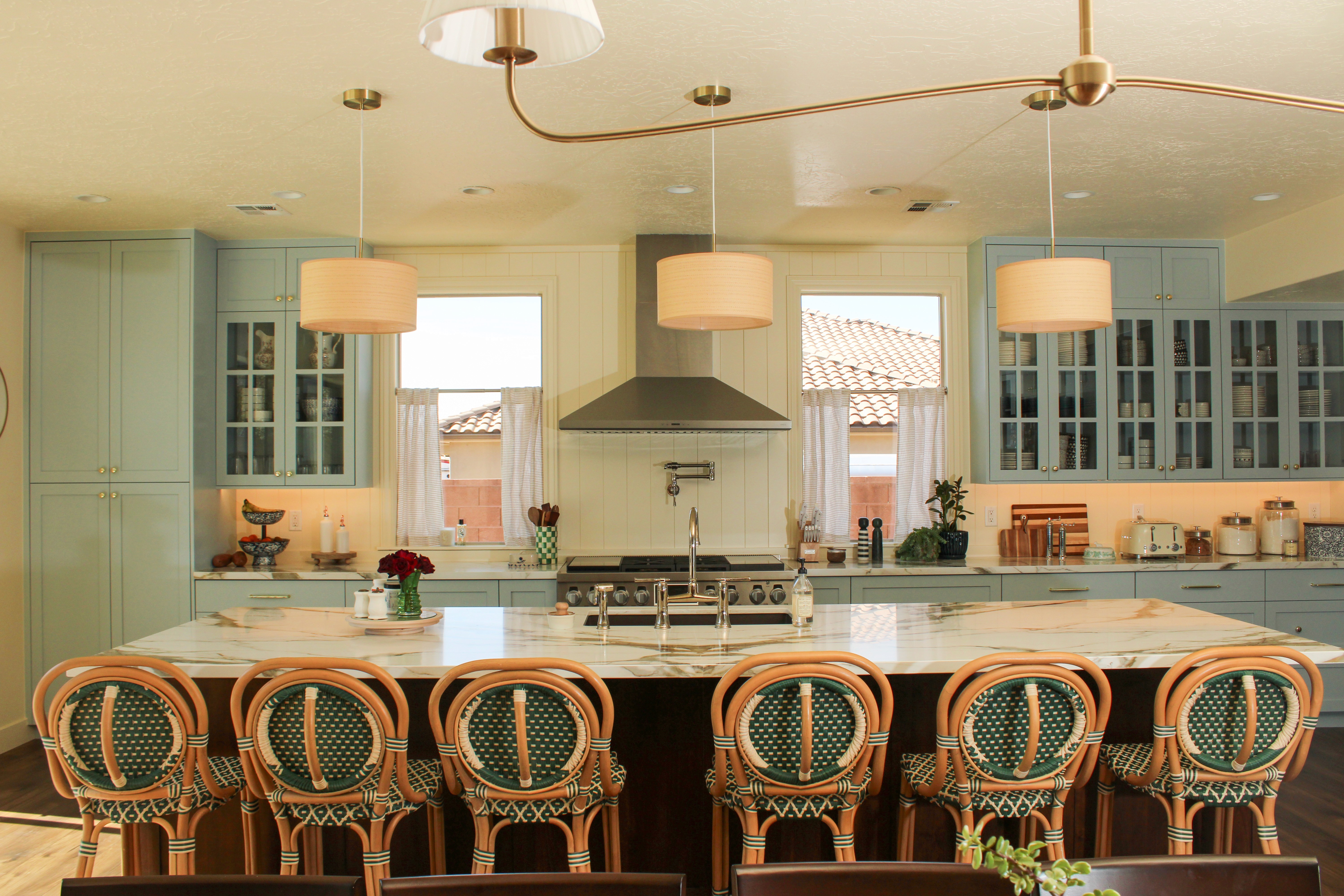 Kitchen of a custom St. George, Utah home with modern finishes, painted cabinetry, a stainless steel range, and a large island.