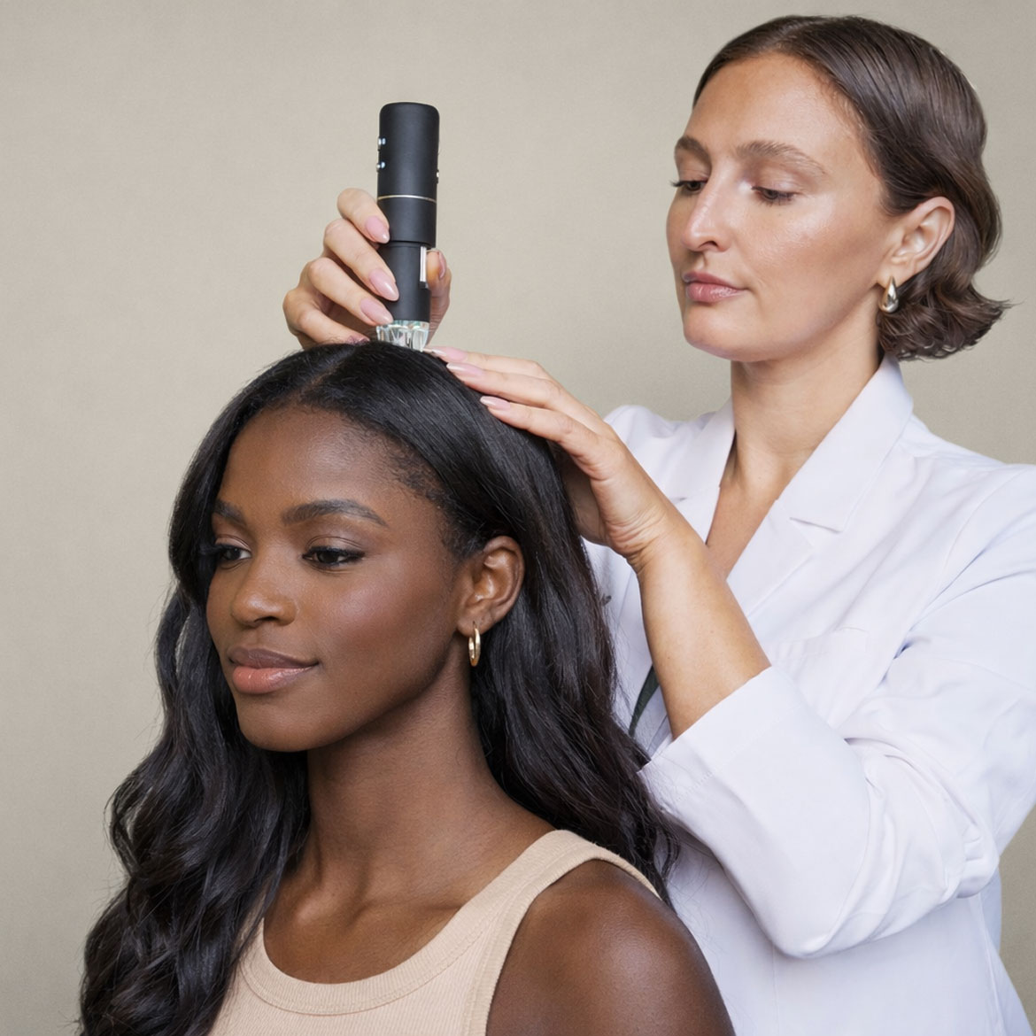 A hair care professional applying a treatment to a client's scalp in a salon setting.