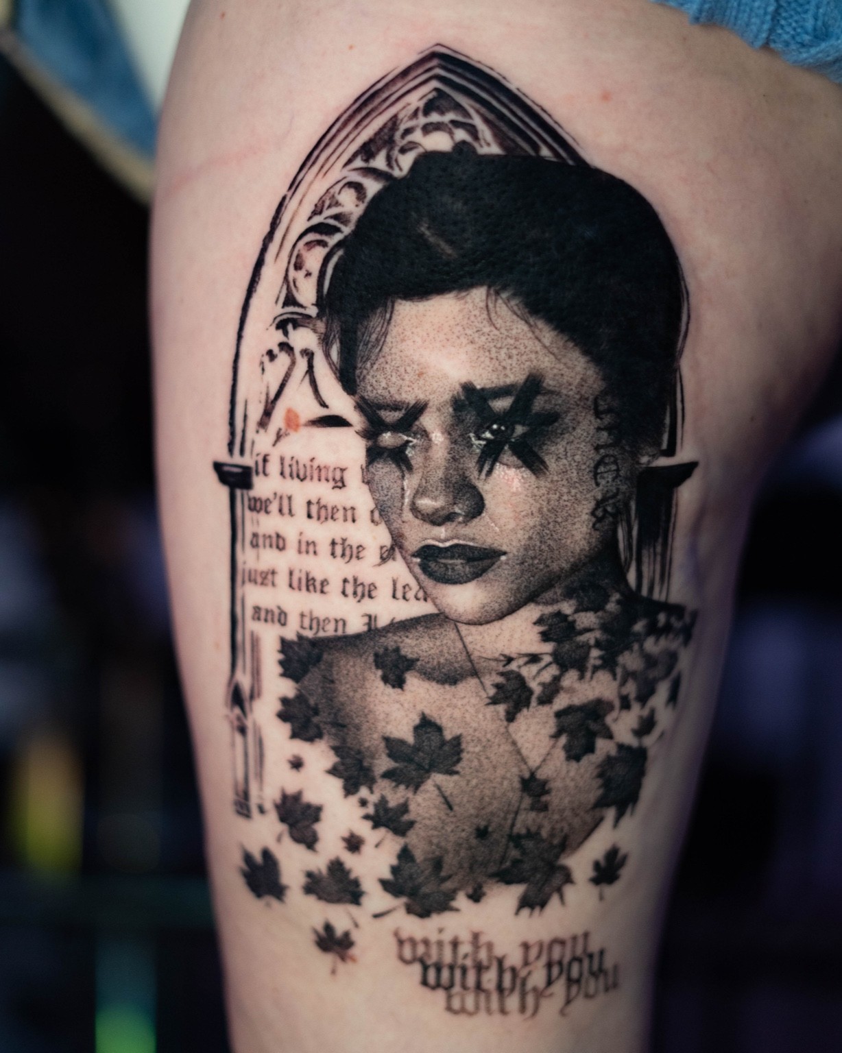 Highly detailed black-and-grey portrait tattoo of an elderly woman wearing a vibrant red and pink floral scarf, set against the silhouette of Russian Orthodox domes. A tribute piece merging realism with cultural symbolism. Tattooed by Samma Charles Art in Boston, MA and Oxford, UK.