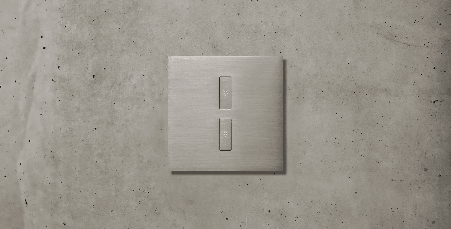 Brushed metal double light switch on concrete wall