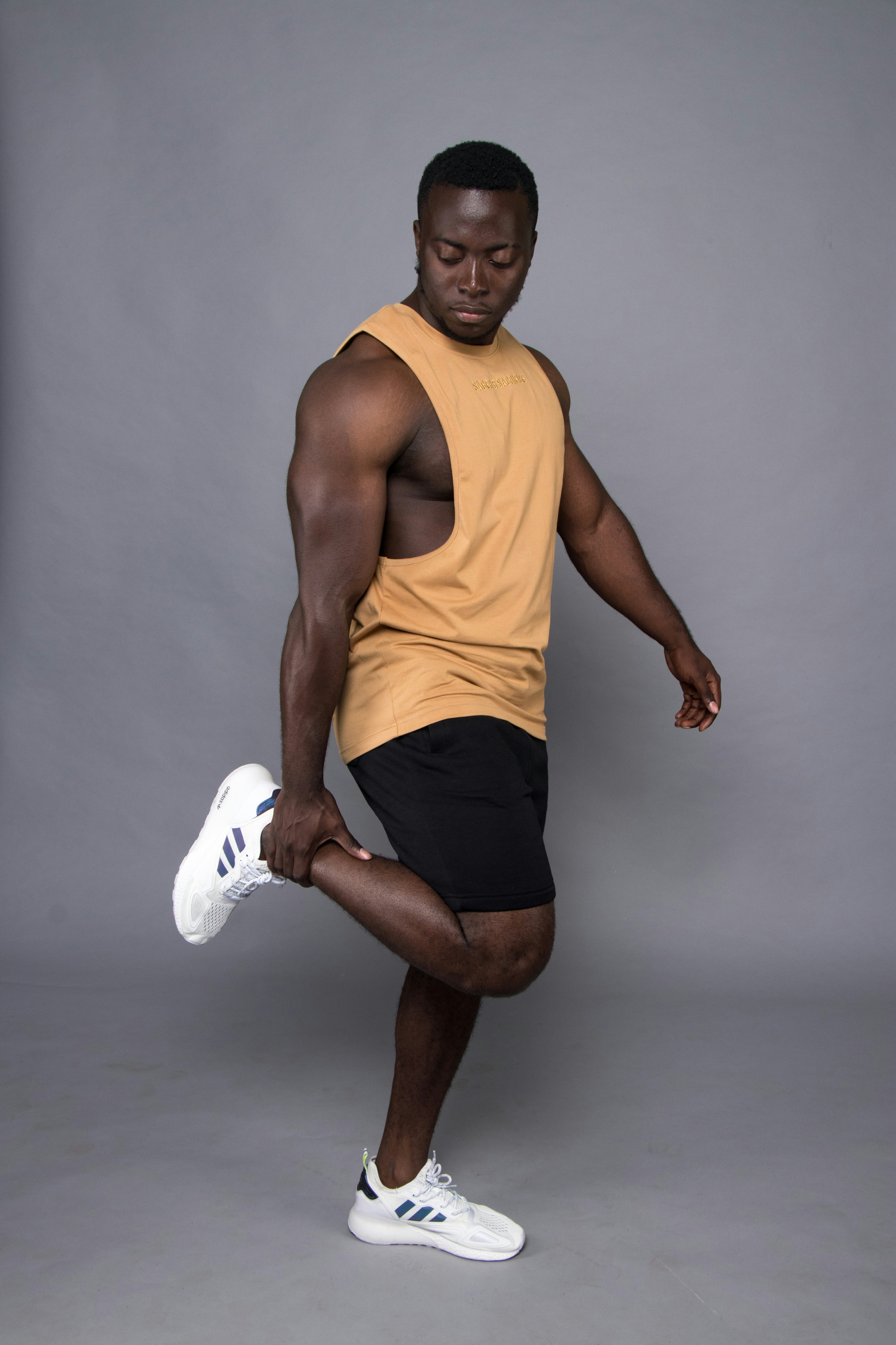 man in yellow tank top and black shorts