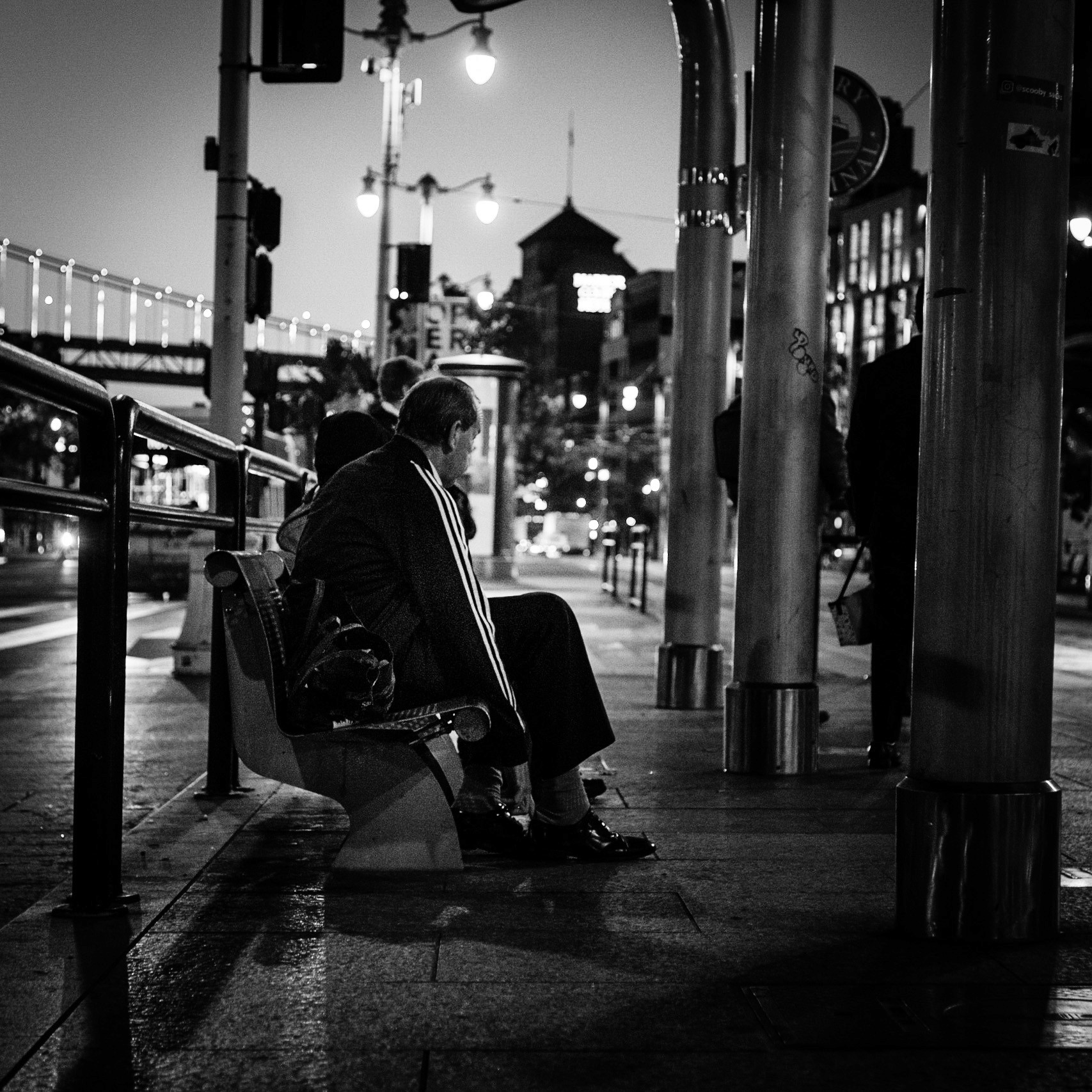 Two people sitting at a bus stop