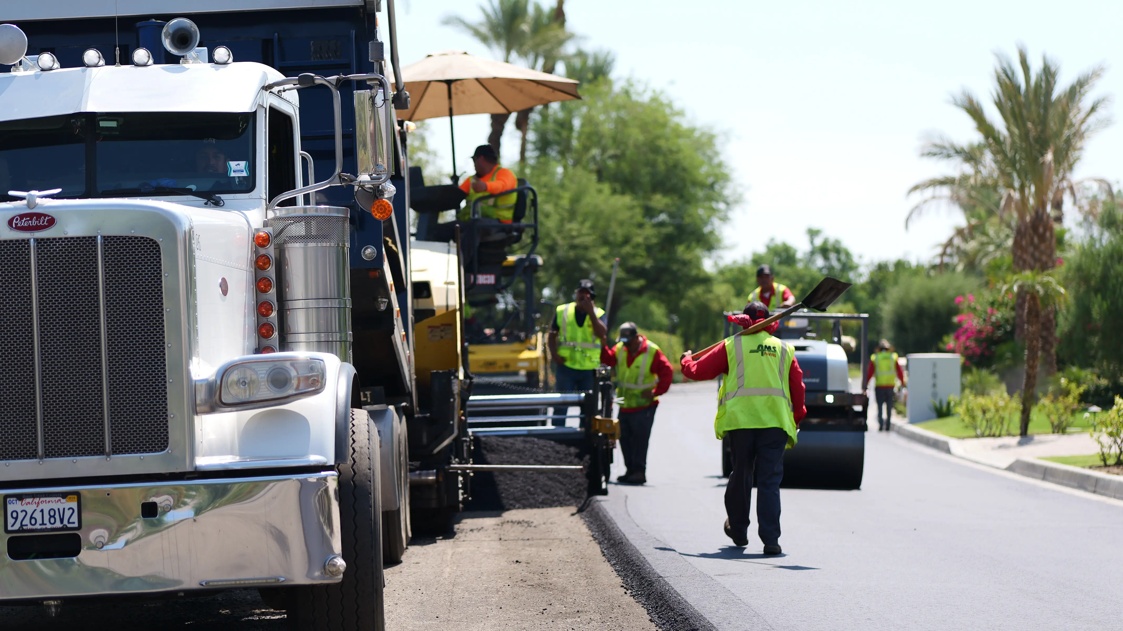 Asphalt paving vehicles and equipment all lined up mid-project