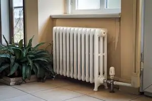 Un radiateur collé contre le mur de la pièce d'une maison sur Nancy