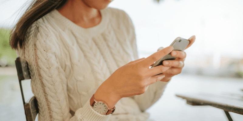 Seorang pelanggan runcit sedang menghantar mesej di telefon pintar.