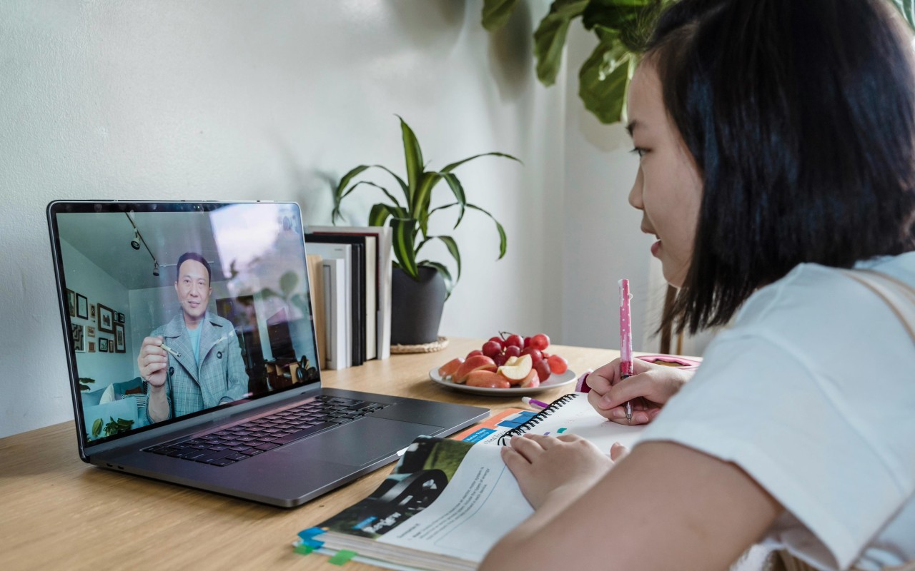 A young girl watching an online course on her laptop.