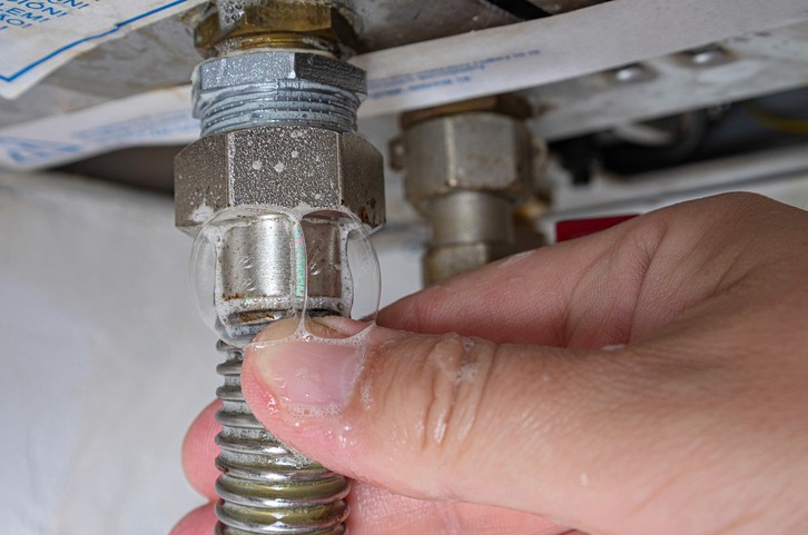 Close-up of residential gas line connection being inspected for leaks in Toronto home.