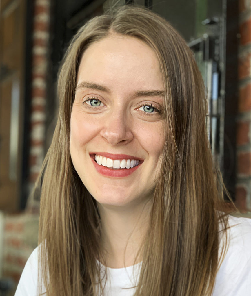 Brunette woman with blue eyes smiling, student Alex Mooney