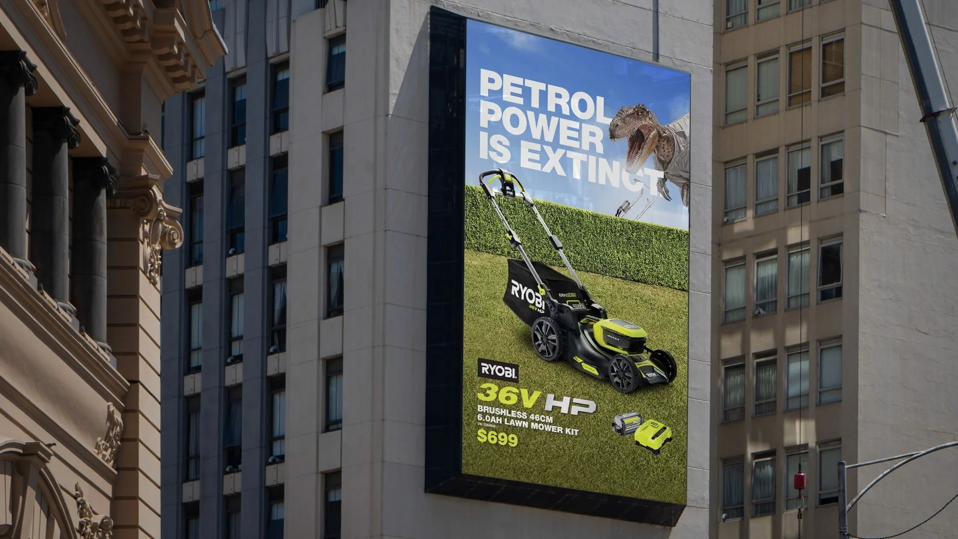 Building-side billboard 'Petrol power is extinct.' with a Ryobi 36V HP mower on a lawn and a dinosaur peering over a hedge