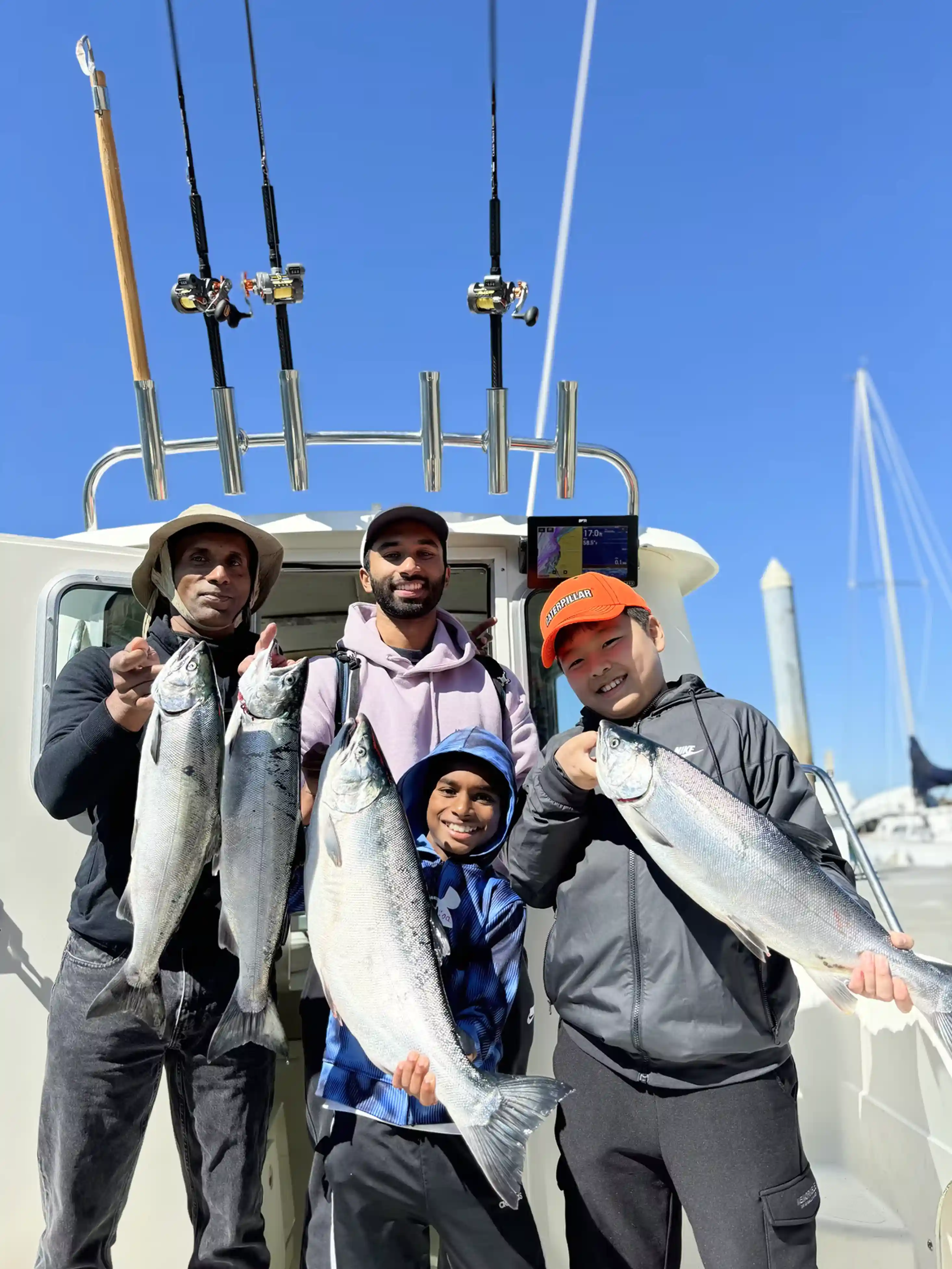Kids and adults holding big salmon