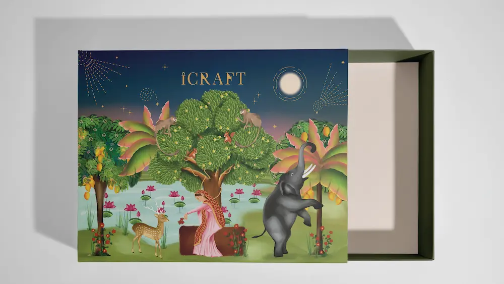A decorative box features an elegant design with a whimsical scene of a woman seated under a tree surrounded by an elephant and a deer, set against a vibrant backdrop of palm trees and a starlit sky with lily pads.