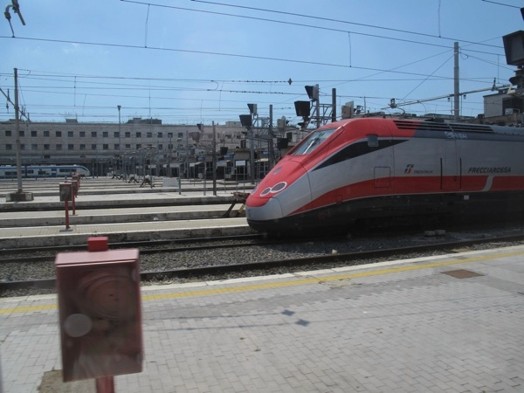 A photo of a red and white bullet train in a station.