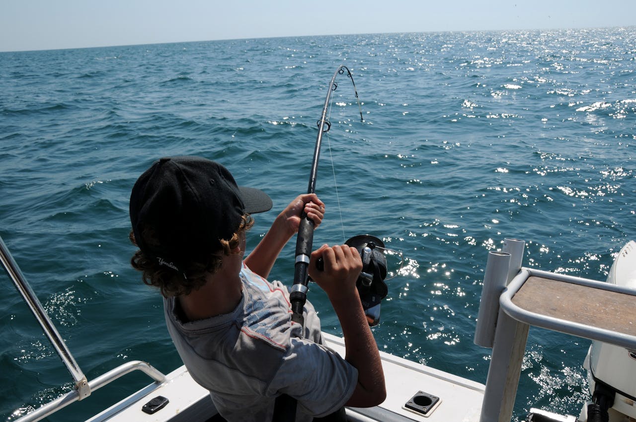 Bakck view of a man reelin in his catch  during a fishing trip.