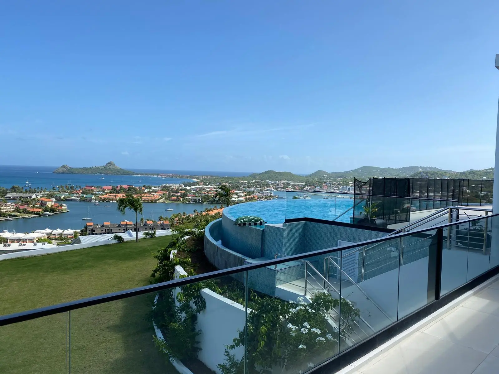 Balcony view from The Hill Residence in St. Lucia by Atelier International, overlooking the infinity pool, Rodney Bay marina, and Pigeon Island beyond.
