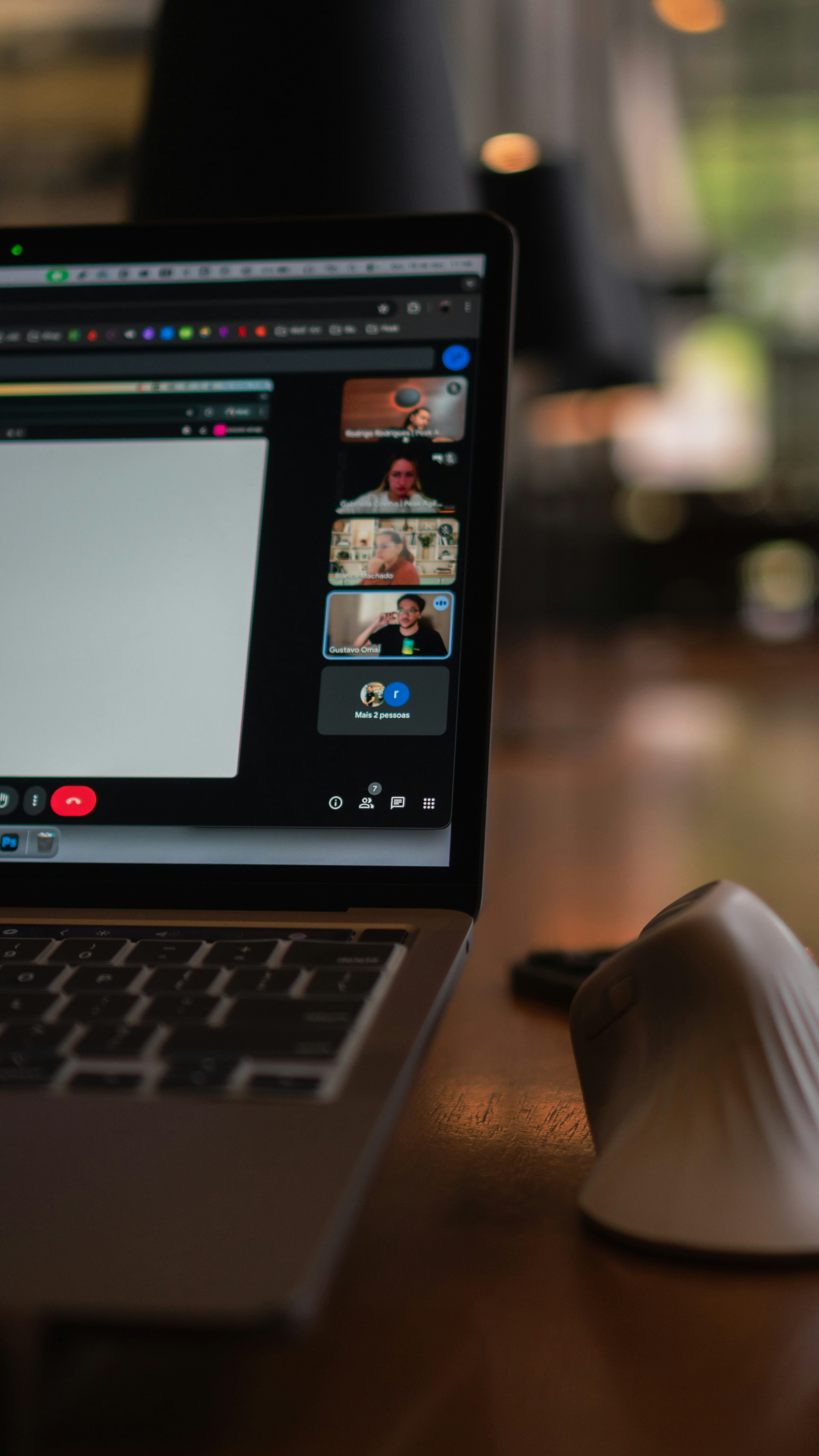 Laptop screen showing a video conference with multiple participants.