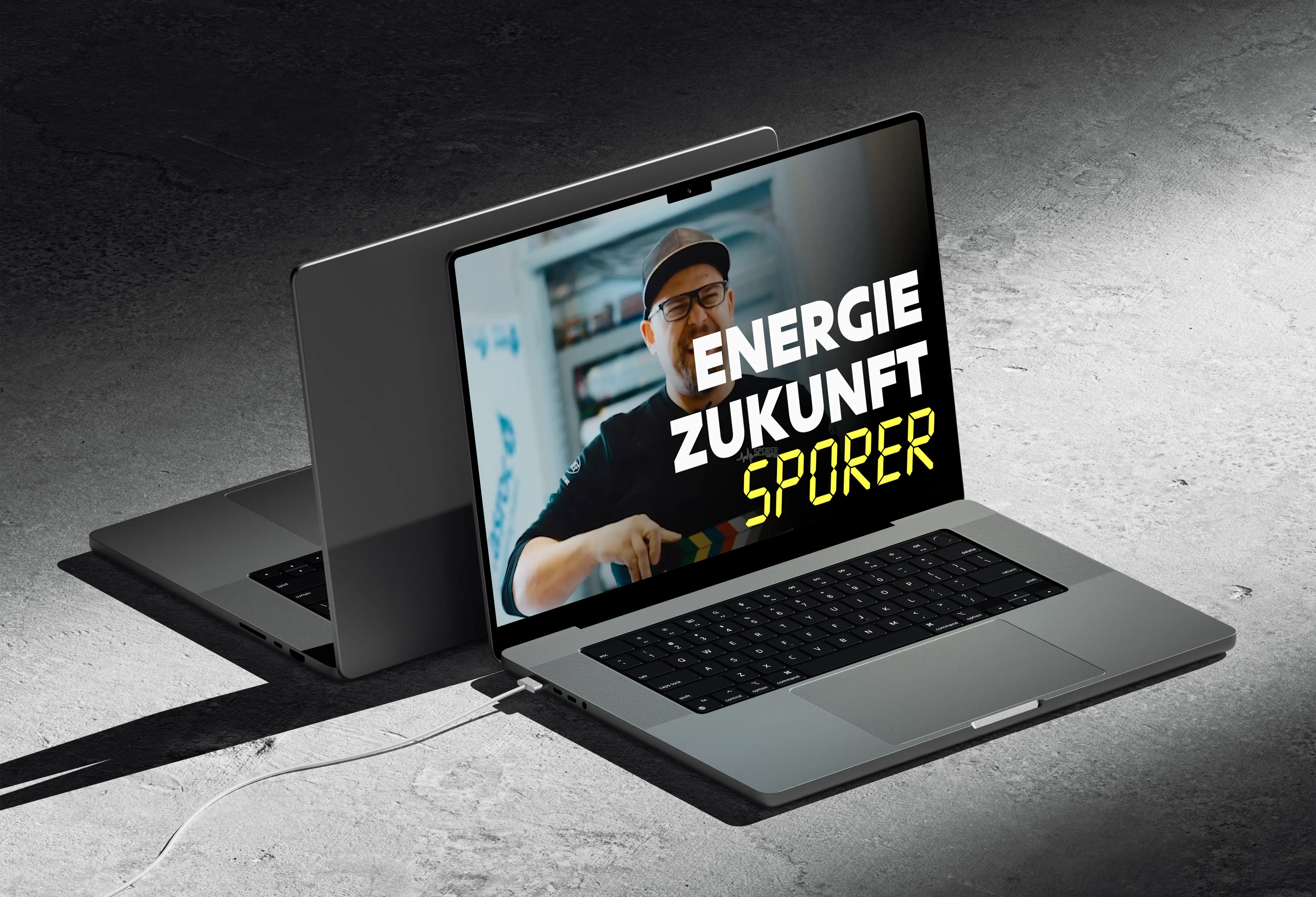 Laptop displaying the Sporer website with the tagline 'Energie Zukunft Sporer' and an image of a smiling person in the background.