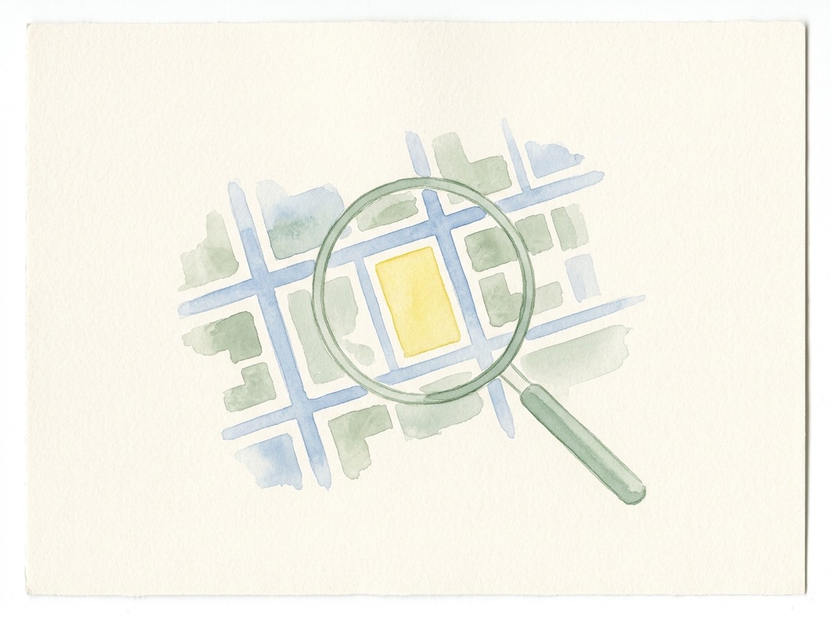 Watercolour of a street map with a magnifying glass held over one highlighted block.