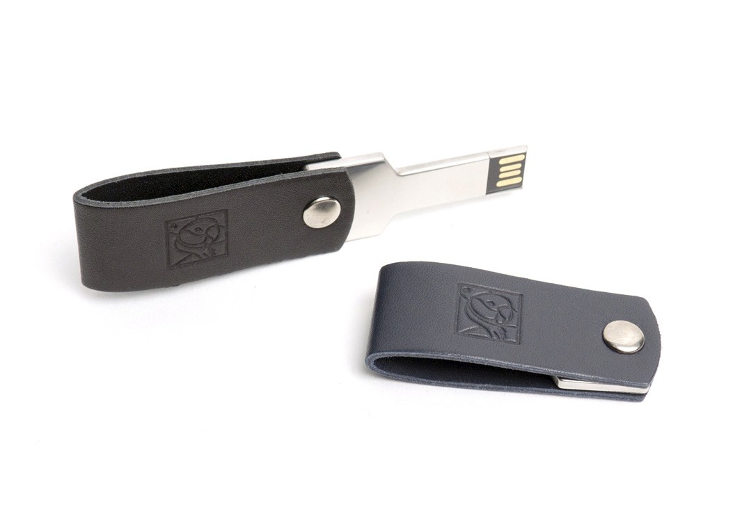 Two leather USB drives; a black one is swivelled open to show the metal connector, while a blue one lies closed next to it.