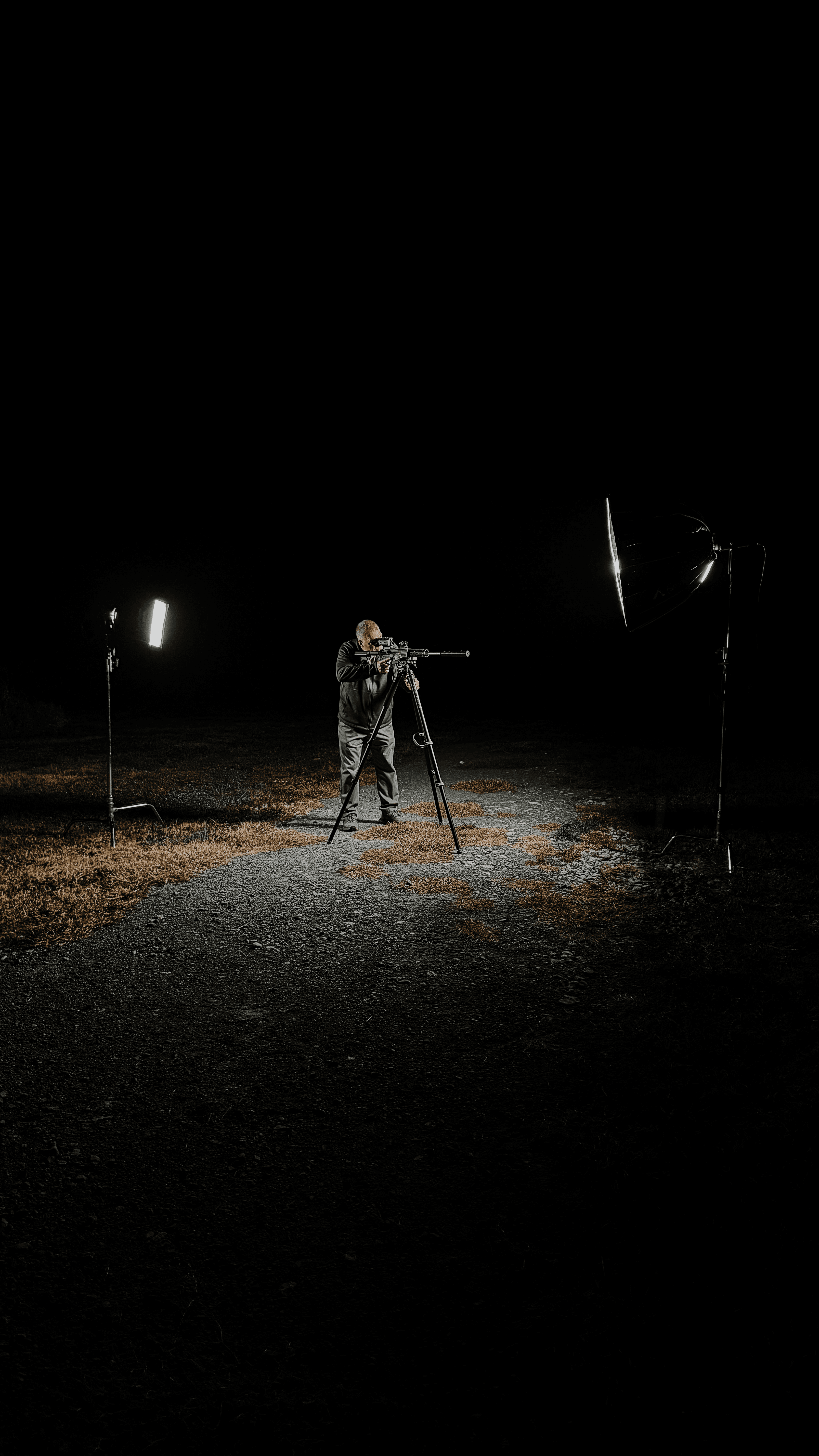 Group of people gathered around a wooden table with laptops, shaking hands during a team meeting.