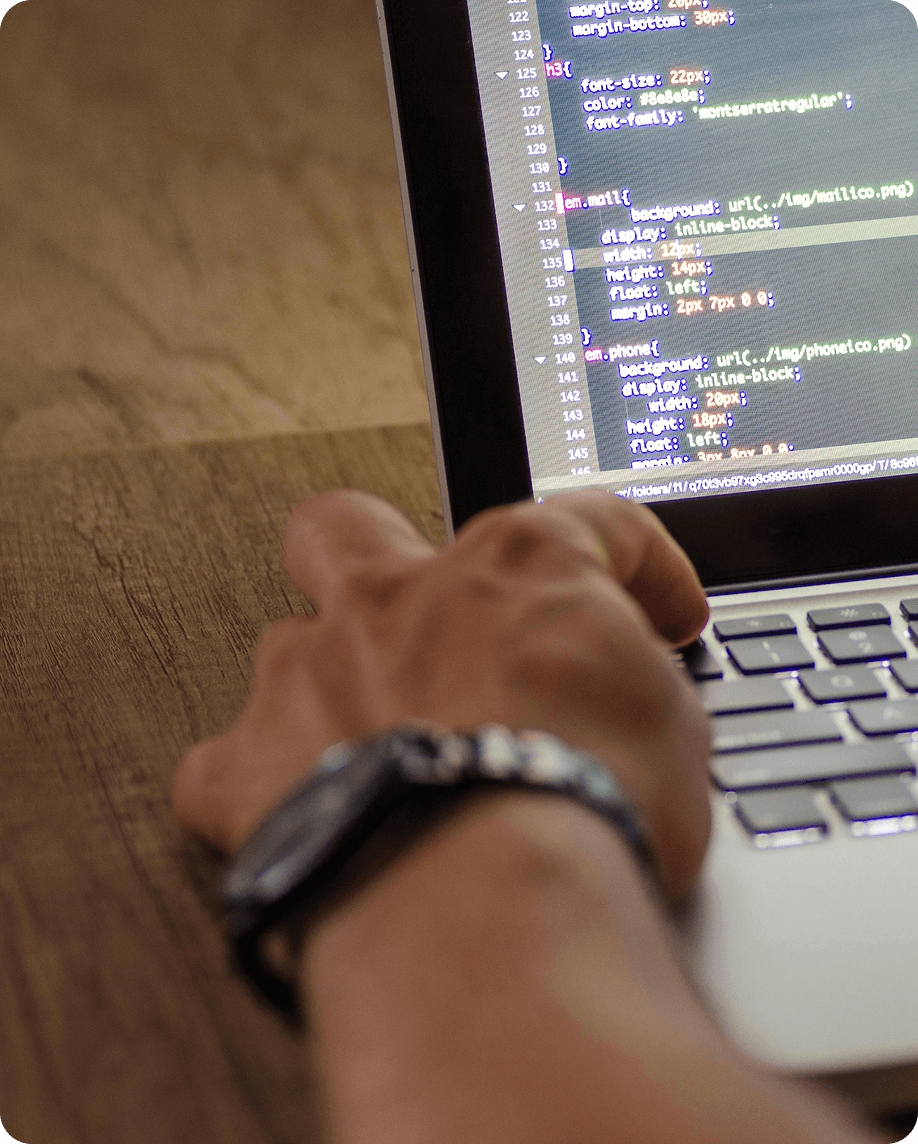 Hands typing code on a laptop