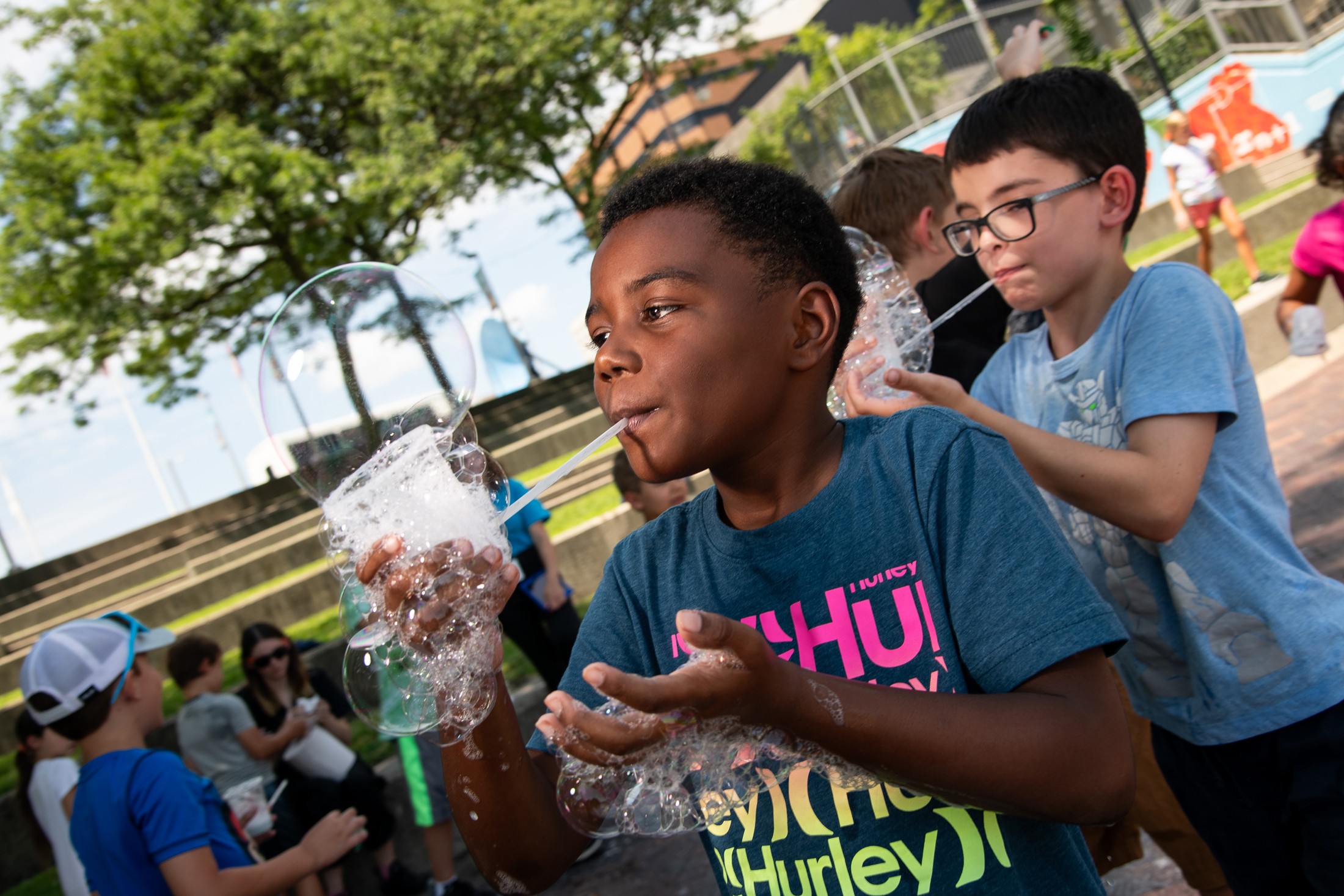 A boy blows bubbles.